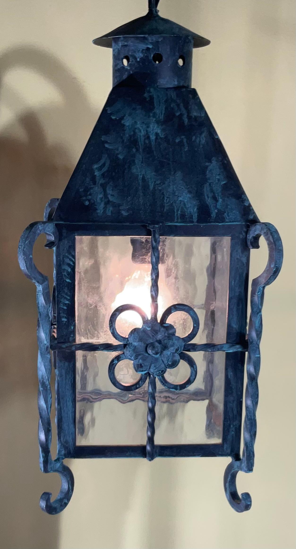 

Questa elegante lanterna sospesa in stile Mizner è un vero e proprio pezzo di storia e una testimonianza dell'arte di epoche passate. Realizzata in ferro massiccio e caratterizzata da intricati dettagli forgiati a mano, questa lanterna emana