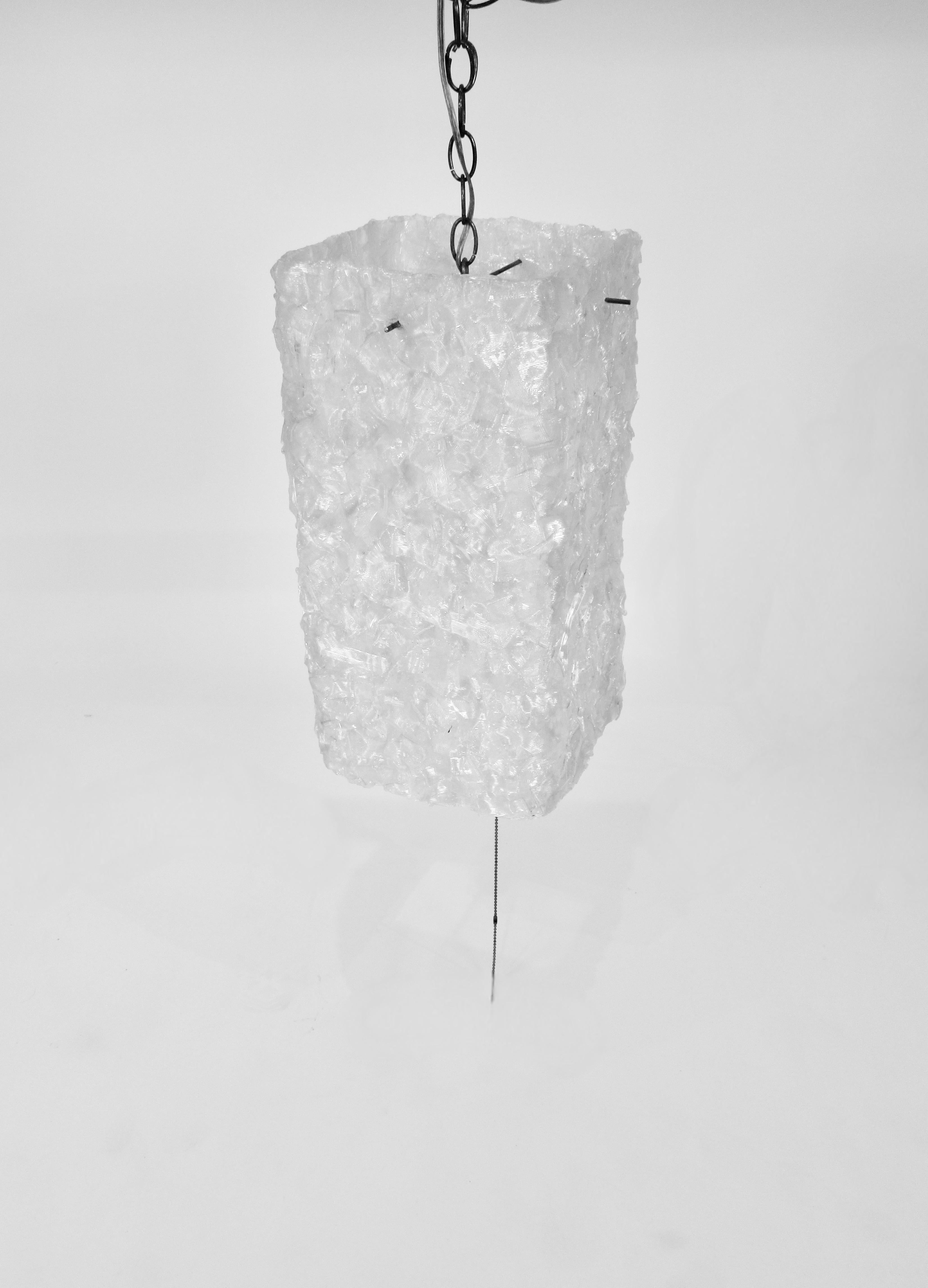 Pressed ribbons of white plastic form this tall rectangular hanging lamp. Currently plugs into a socket to hang straight or as a swag lamp. Could easily be hardwired if need be.