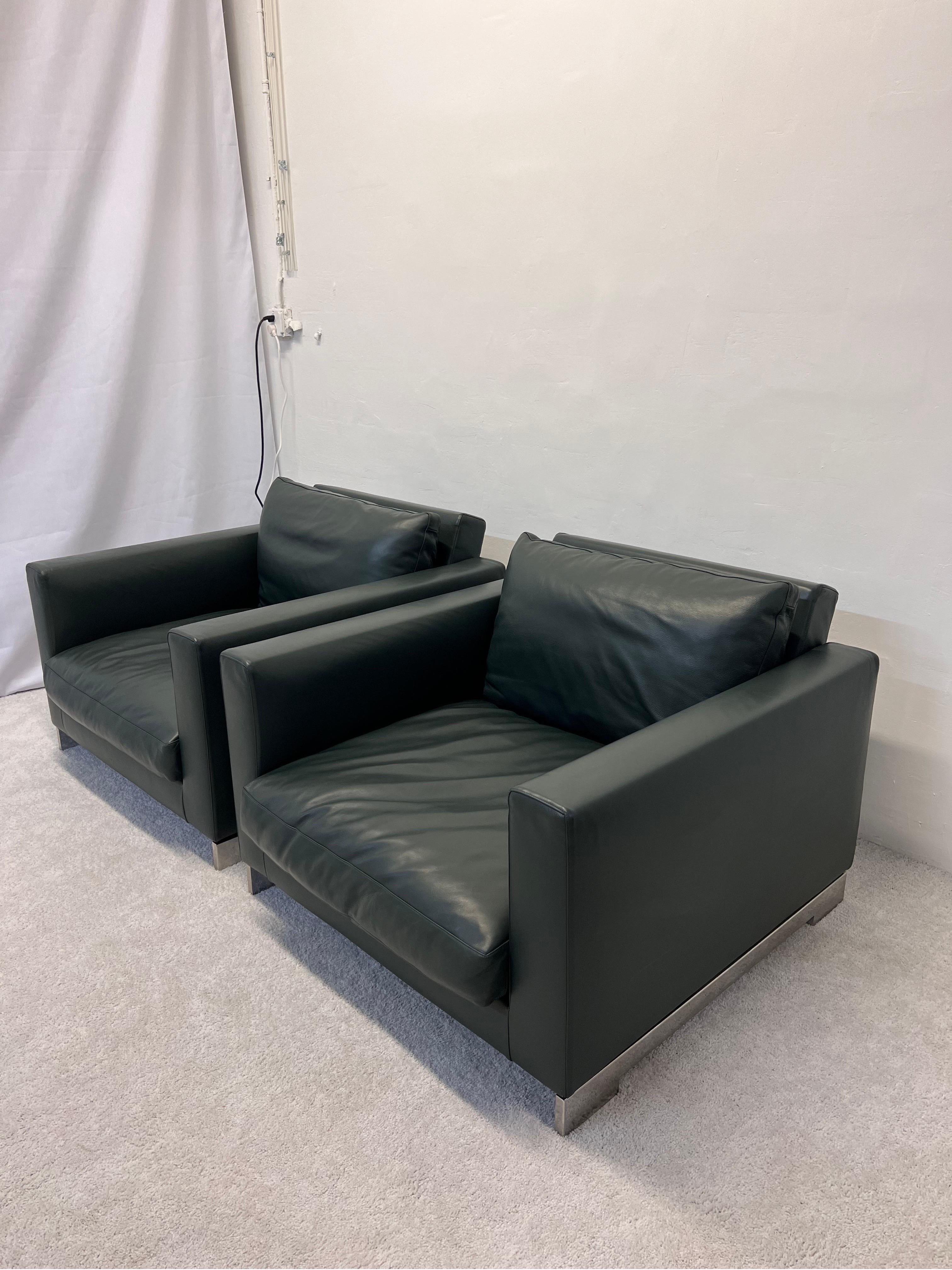 Ein Paar Reversi-Sessel aus jagdgrünem Leder, entworfen von Hannes Wettstein für Molteni & C. Das Reversi-Paar, bestehend aus Pouf und Sessel, ist fast ein Rückgriff auf das Art déco: gediegene Formen, aber mit großzügigen, gemütlichen Volumen. Alle