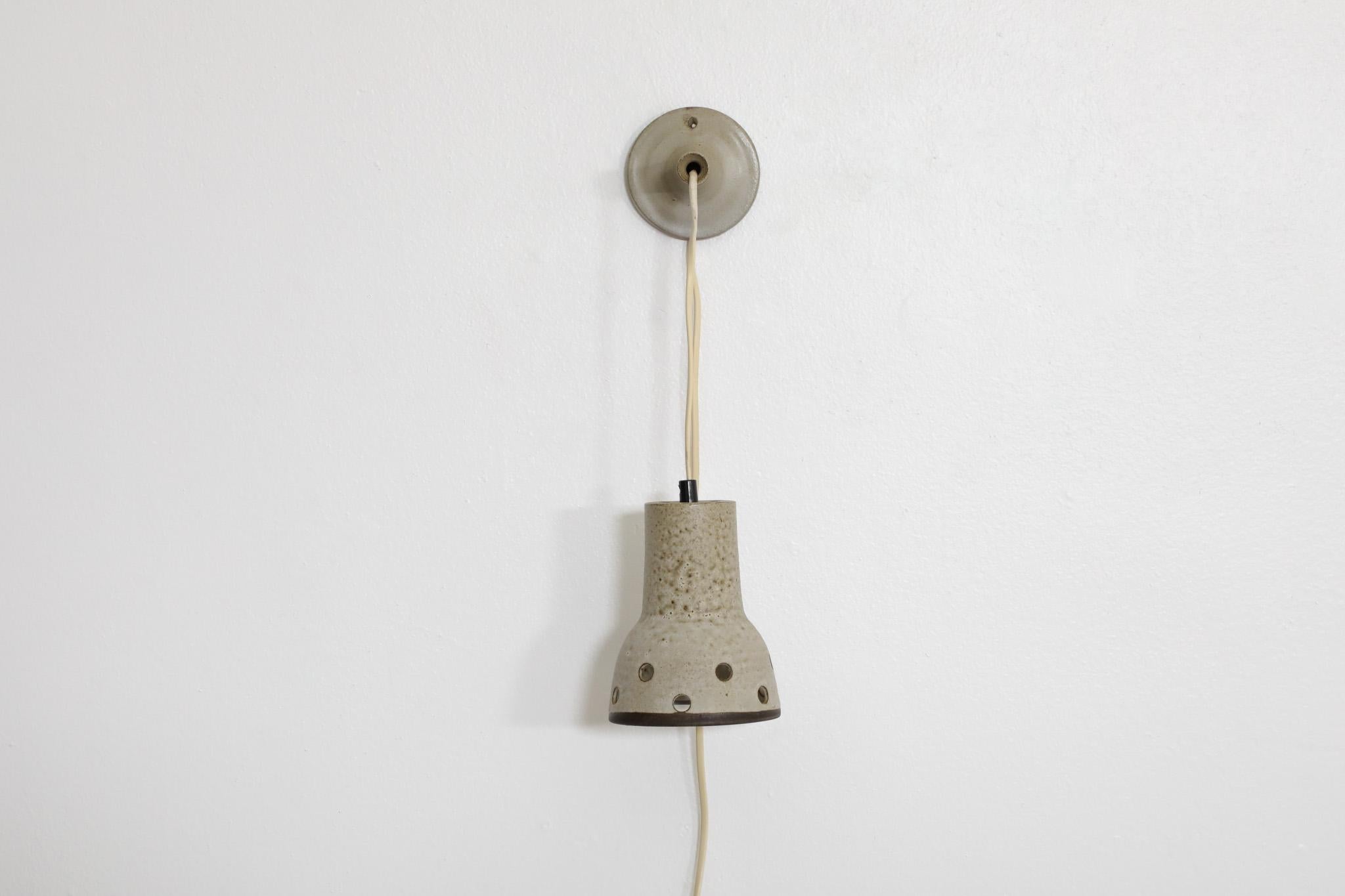Mid-Century, 1960's, ceramic wall sconce/pendant with dove gray glaze and circle cut-outs. Designed by renowned Dutch ceramicist Hannie Mein. Cute wall lamp, perfect for providing gentle lighting. In original condition with wear consistent with its