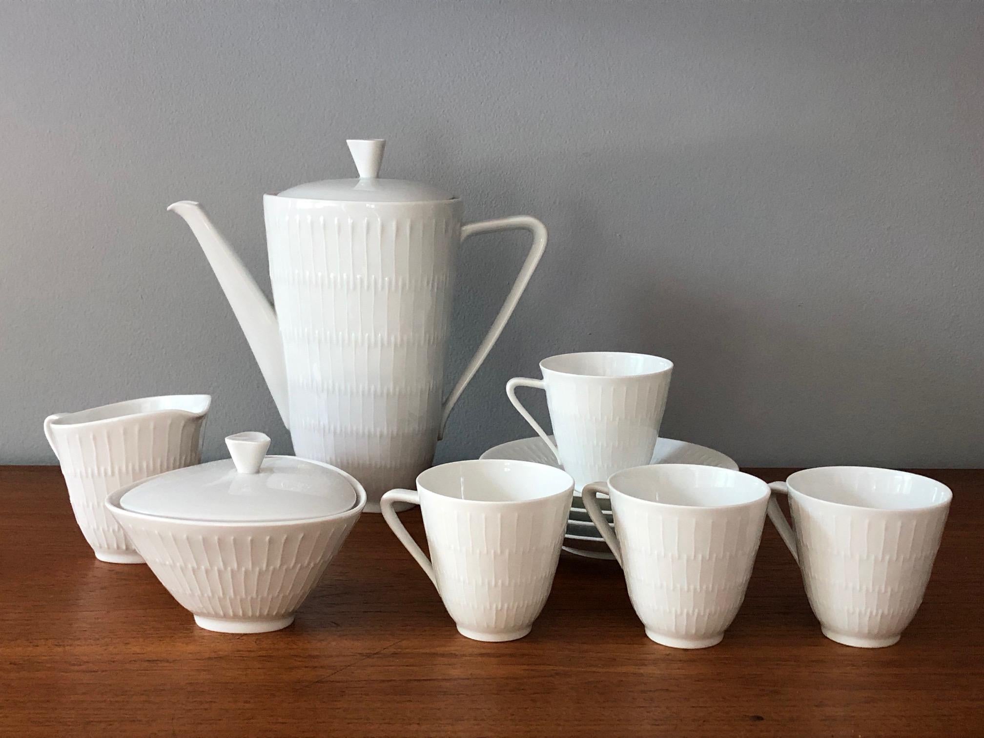 Elegant 1950s white porcelain 'Apart' coffee/tea set from Hutschenreuther Selb, Germany. The set includes 4 cups, 4 saucers, a coffee pot, a creamer/milk jug, a  sugar bowl, a dessert plate,e and a small serving dish with saucer (14-piece set).