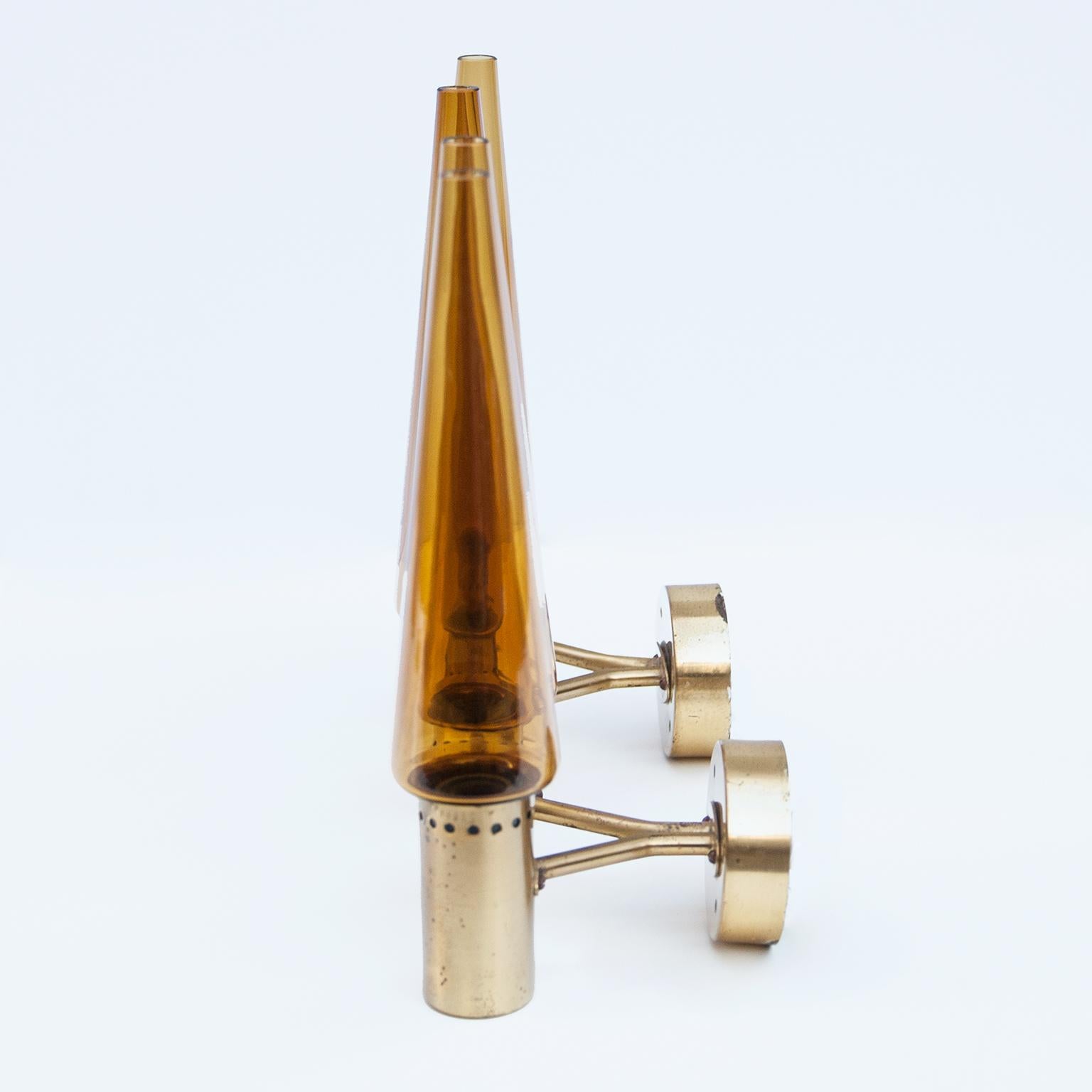 Pair of sconces by Hans Agne Jakobsson in brown orange glass and a brass wall bracket. 
The complete set includes seven early wall sconces by Hans-Agne Jakobsson for his own company in Markaryd, Sweden 1960s. See my other listings.
One features a