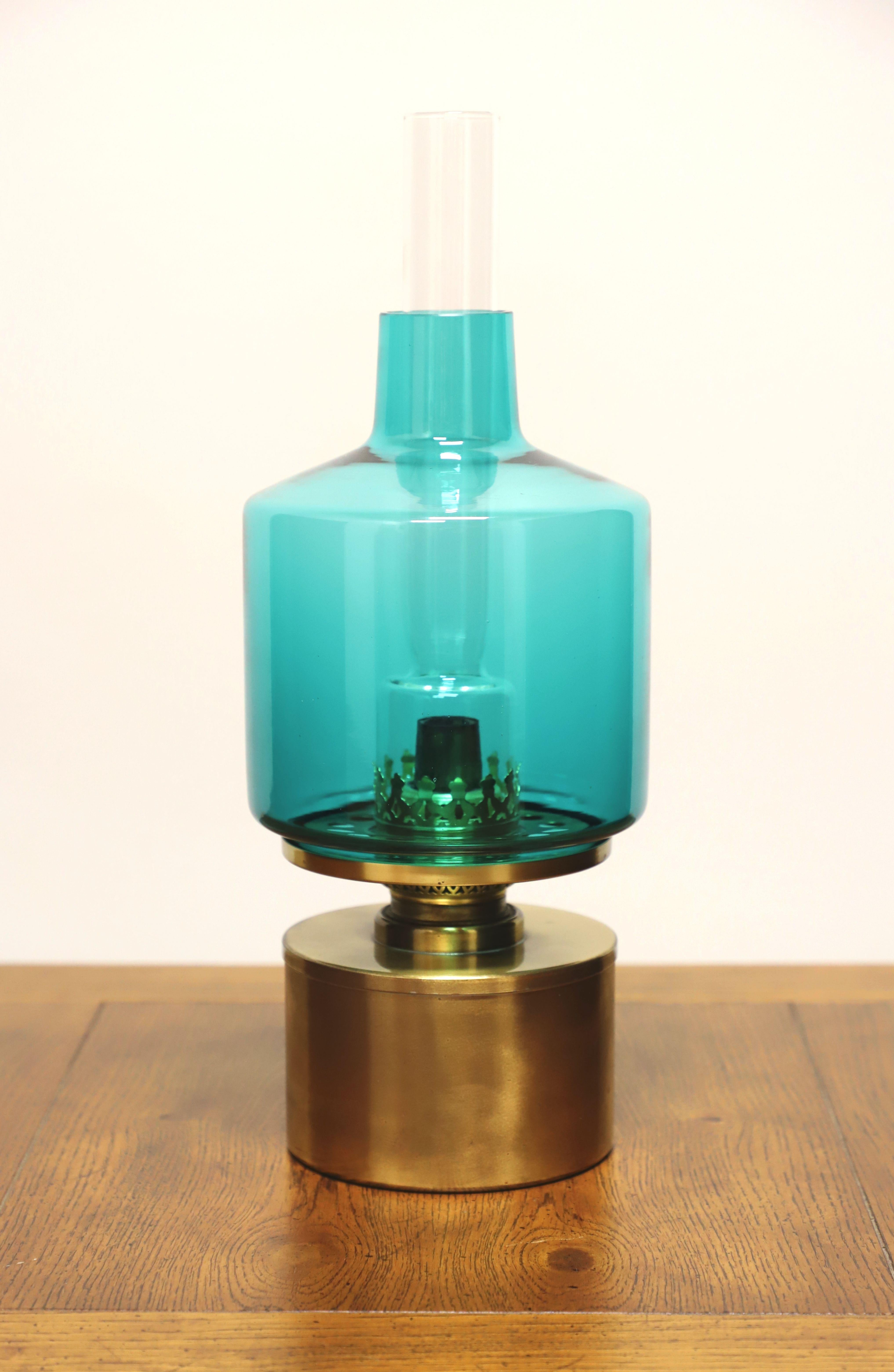 A Mid 20th Century Modern style oil lamp by Hans-Agne Jakobson A/B, the L/47 Model. Solid brass base, glass globe shade, and glass chimney. Features oil holding base with screw off burner for filling, burner with rotary knob for adjusting wick