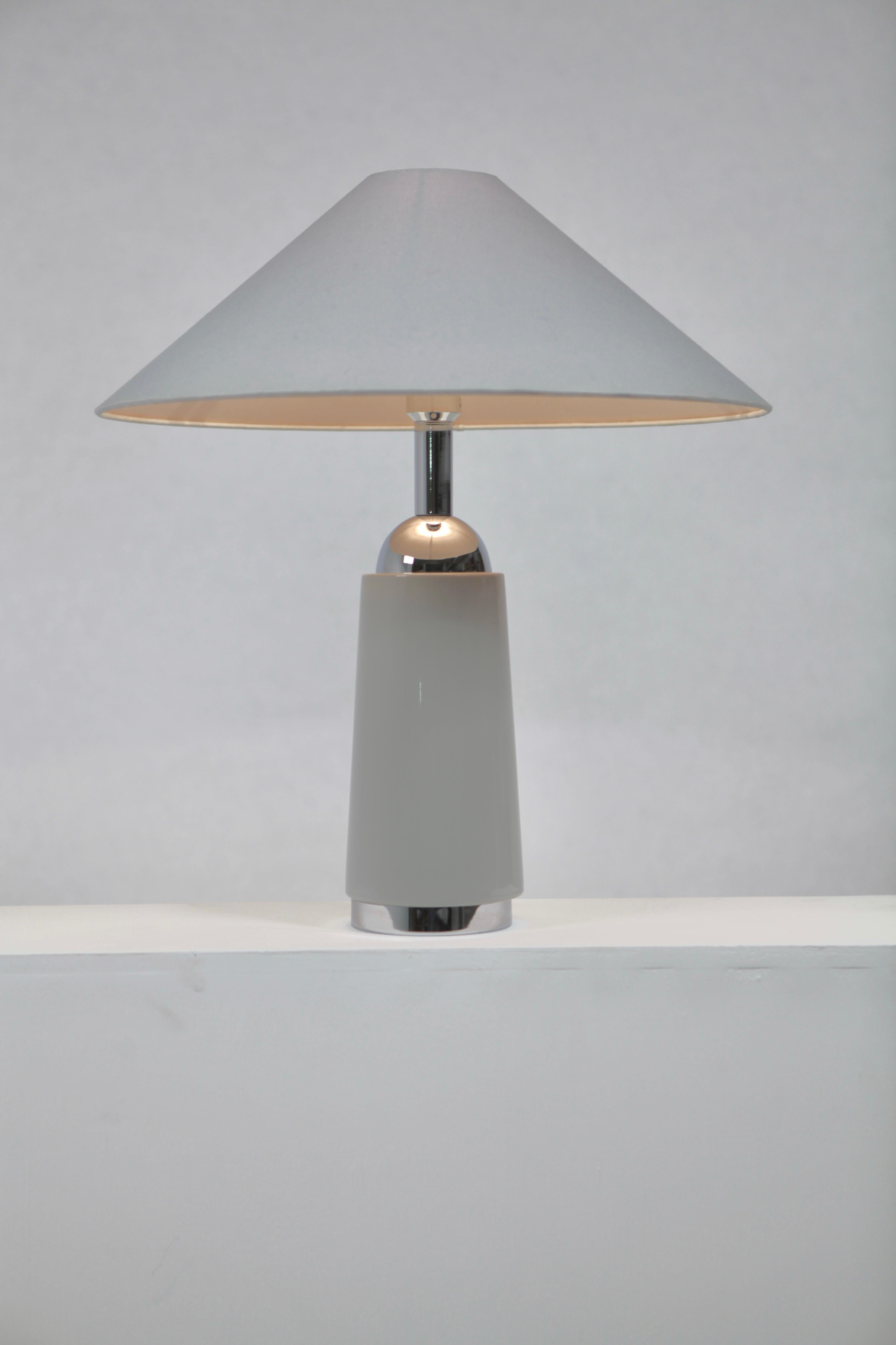 A rare Hans-Agne Jakobsson table lamp in blueish grey faded porcelain and chromed metal in perfect vintage condition. Measures: Height with shade 60cm, diameter shade 52cm, depth base 15 cm, base without shade 45 cm.
Signed with paper label HAJ