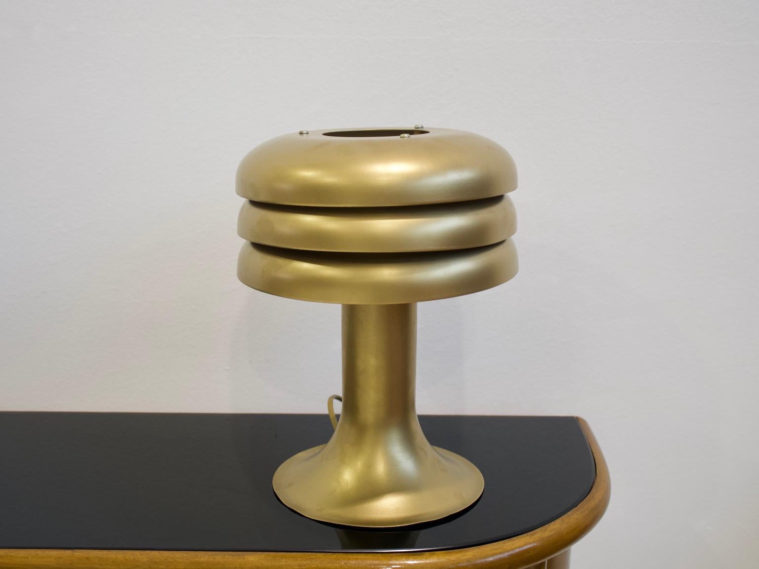 Lampe de table en forme de champignon en tôle, repeinte ultérieurement en couleur laiton. Cette lampe, modèle BN-25, conçue par Hans-Agne Agnes, présente une certaine usure liée à l'âge et une légère déformation de la base du pied, visible sur les