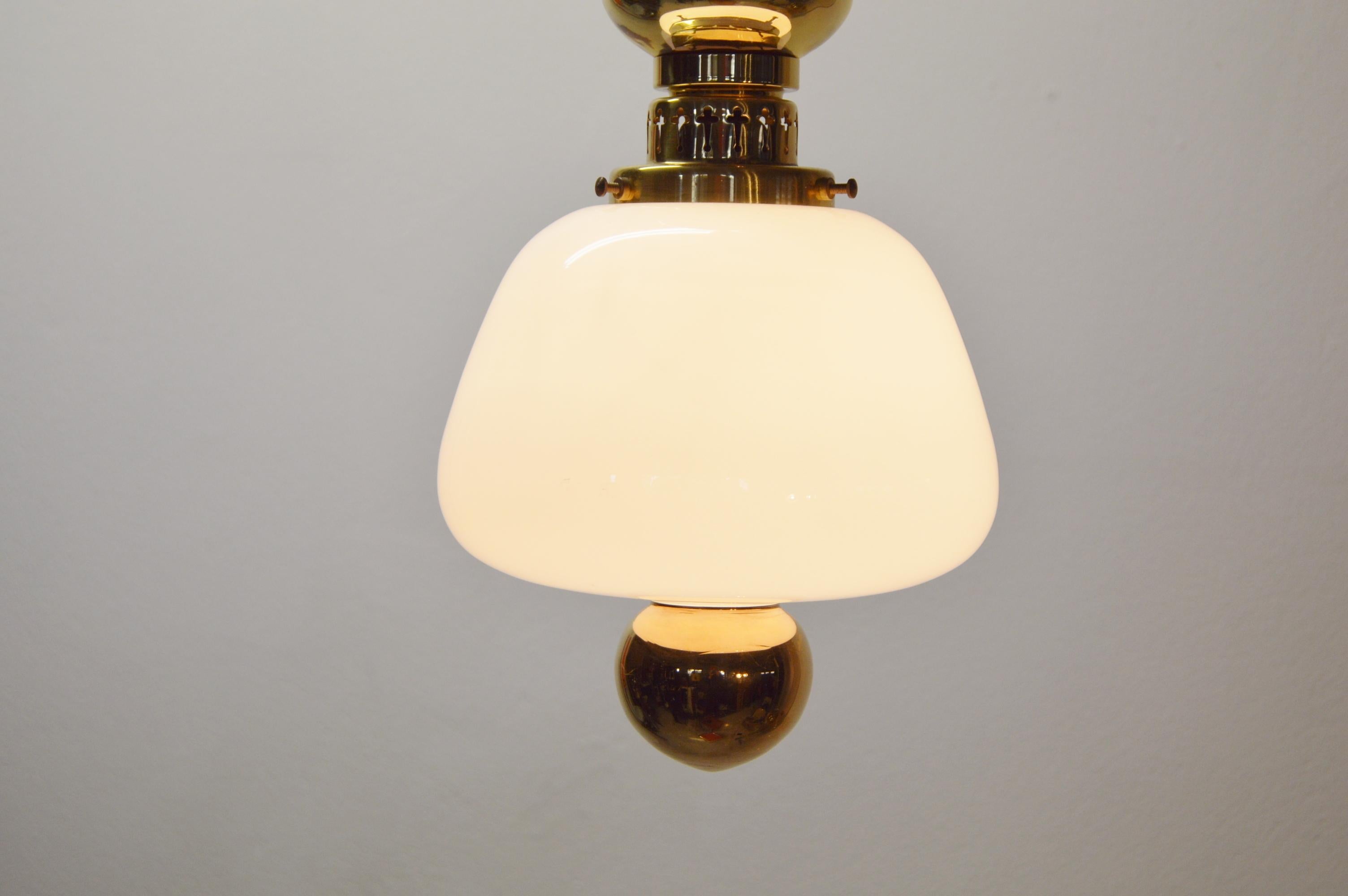 Rare ceiling lamp designed by Hans-Agne Jakobsson.
Glass and brass details with the of Hans-Agne characteristic pattern. 
Gold colored glass in bottom, followed by white opaline glass and then brass. 
The height is adjustable thanks to the