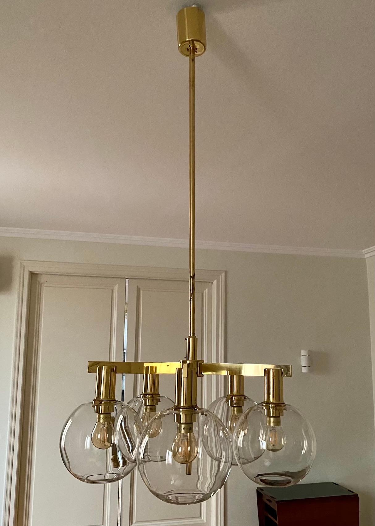 Large brass chandelier by Hans-Agne Jakobsson. Frame made of brass. Five arms with round glass globes. The height of the rod can be shortened on request.