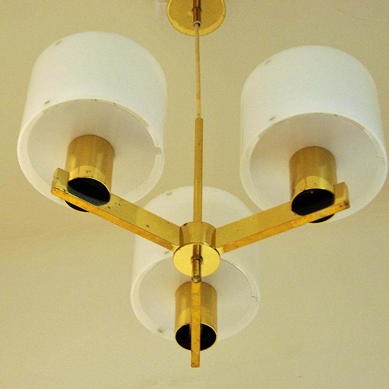 Three armed brass ceiling lamp with white acrylic shades produced in the 1960s.  Designed by Hans-Agne Jakobsson for Markaryd, Sweden.
The frame is in polished brass. Measures:  60 cmH x  38 cmD.  Shade: 14 cmD.

Hans- Agne Jakobsson (1919-2009 )