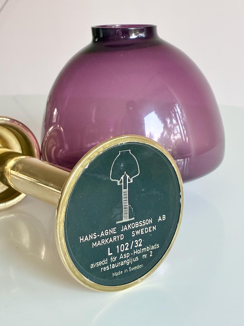 Beautiful candlestick by Hans Agne Jakobsson. 

Burgundy colored glass and brass base with a spring mechanism that push up the candle while it burns. 
Very nice condition. Price for one candleholder. No damages with nice patina.


 