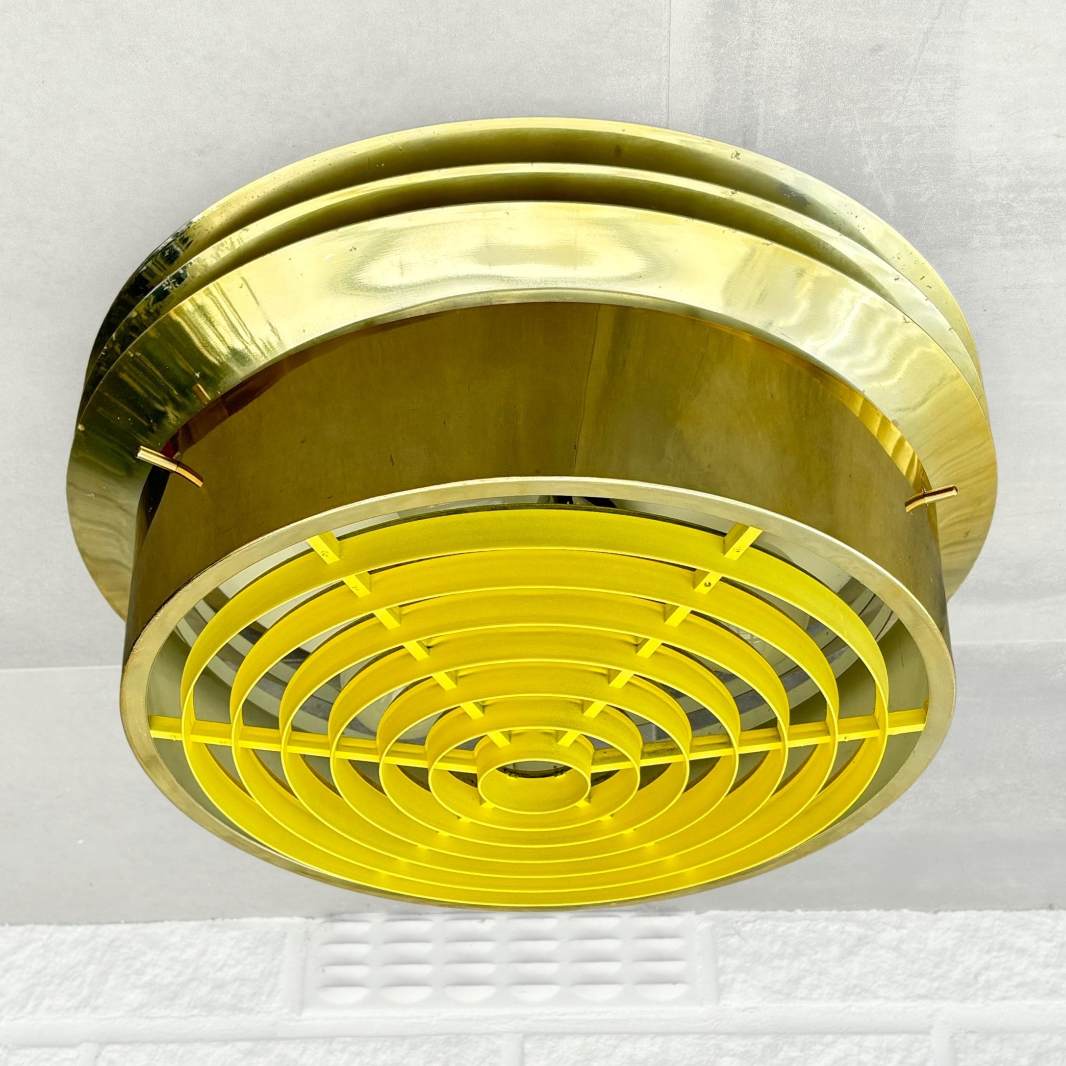 Eine schwedische Deckenleuchte aus den 1960er Jahren, Modell T559/40, entworfen von Hans-Agne Jakobsson. Aus Messing mit drei Lampenfassungen hinter einem gelben Acryldiffusor. Produziert von Hans-Agne Jakobsson AB, Markaryd.

Der schwedische