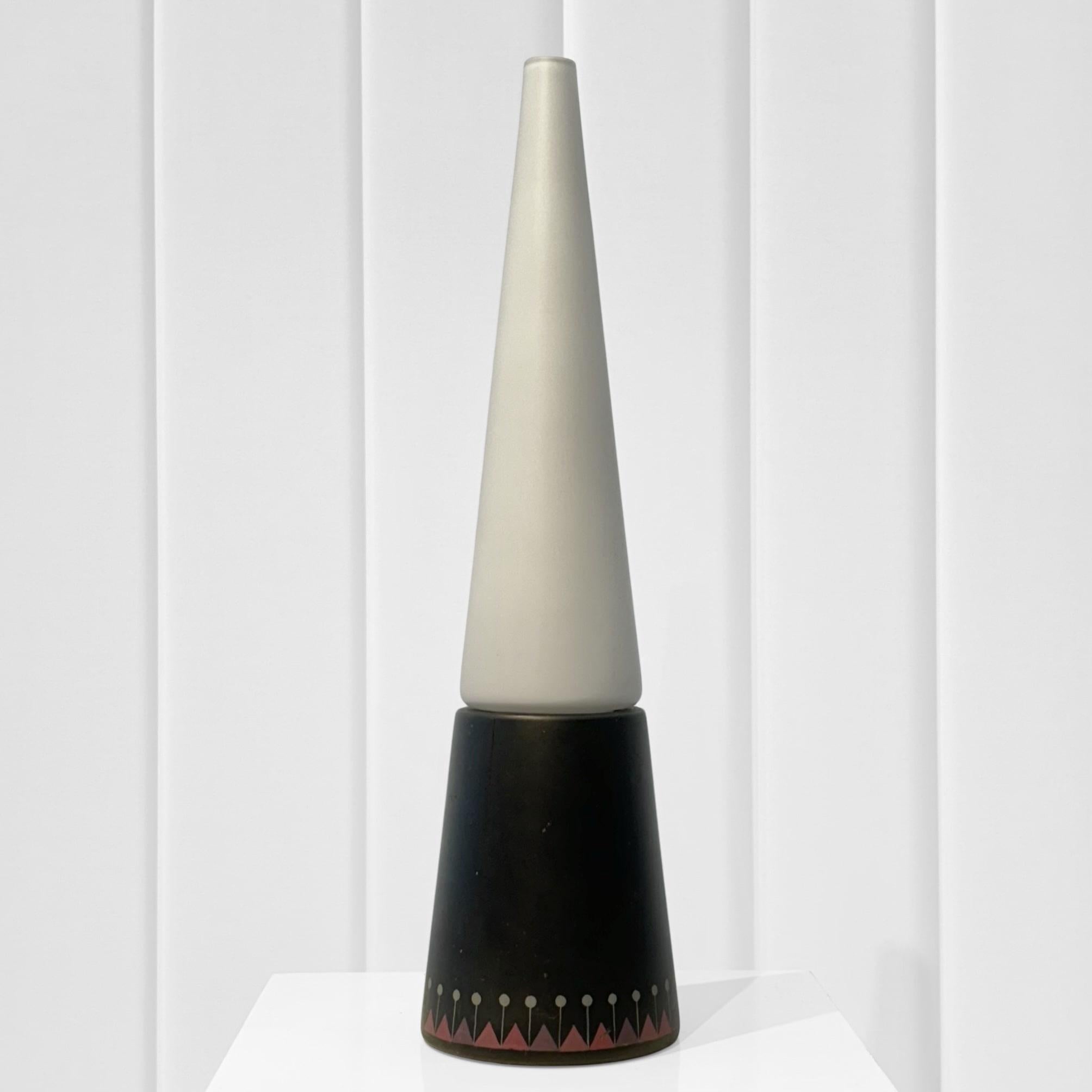 Lampe de table du milieu du siècle conçue et produite par Hans-Agne Agnes, Suède, années 1950. La lampe présente une base conique en bois peint, supportant un abat-jour en verre opale. La base est ornée d'un motif géométrique de triangles et de