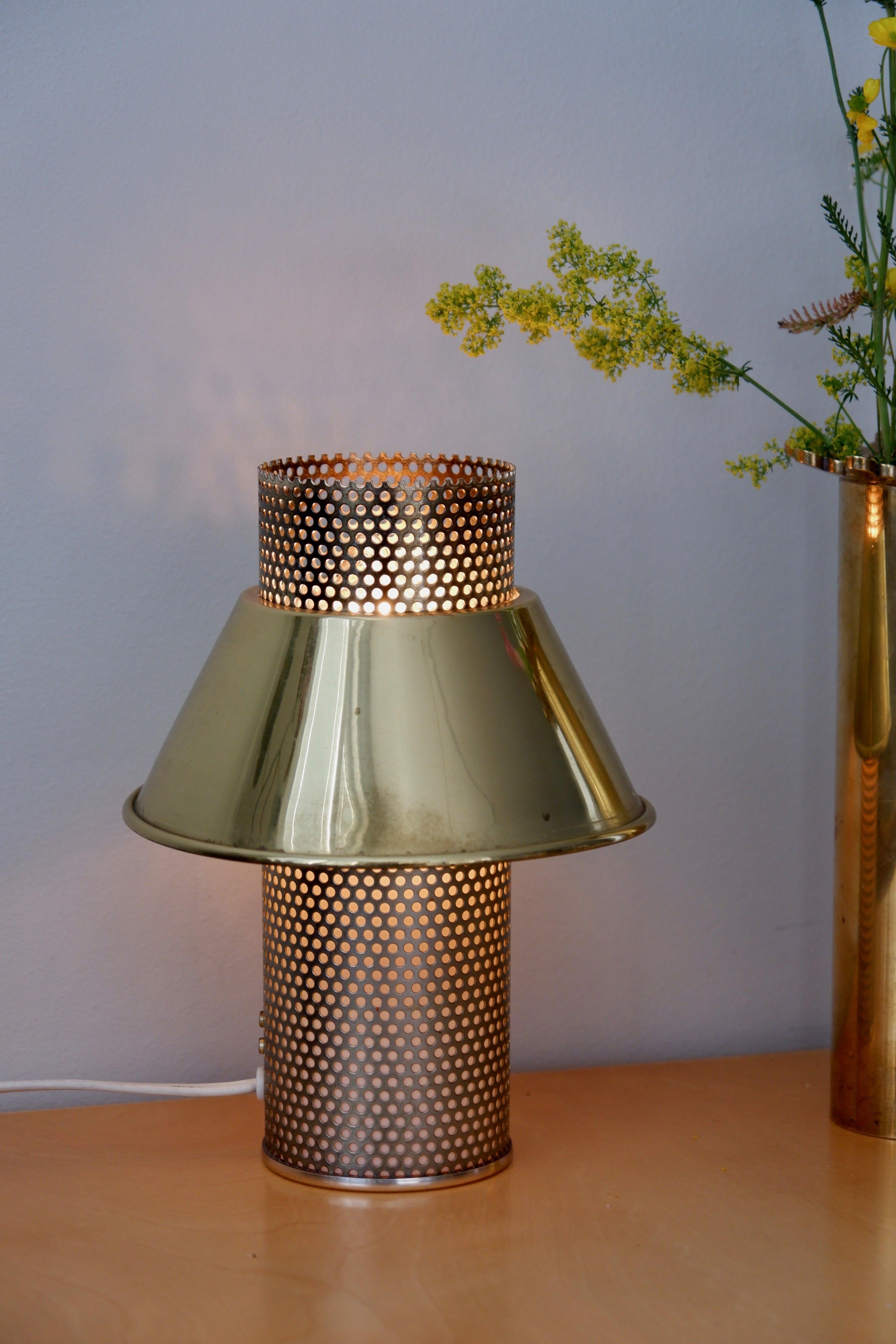 Minimalist table lamp designed by Hans Agne Jakobsson in the 60's and produced in Markaryd sweden, model B202. The lamp is composed by a solid brass shade and an aliminum perforated core. The lamp is stamped by the editor. Dimensions : H : 23 cm / L