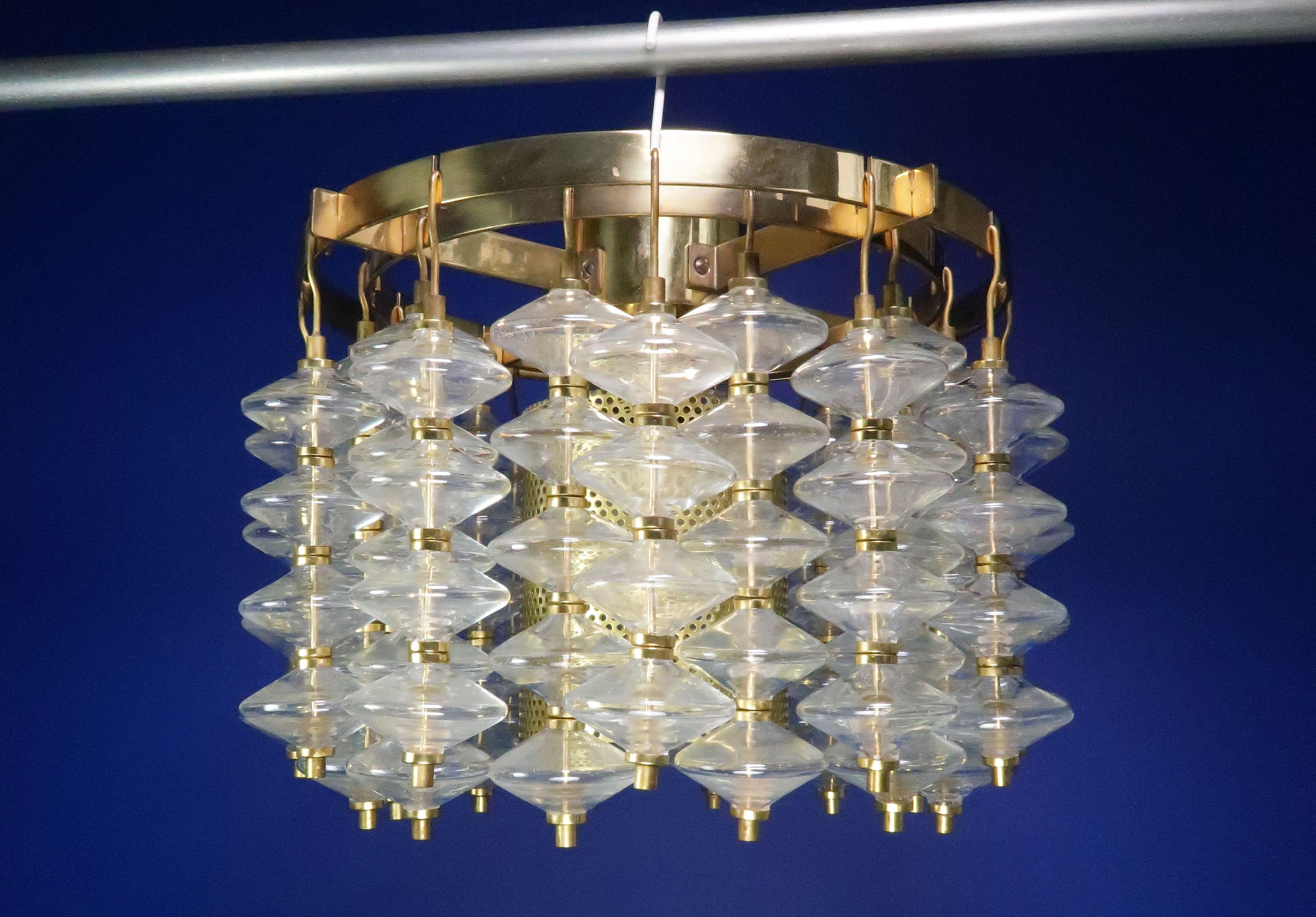 Stunning Hans Agne Jakobsson glass and brass Scandinavian Mid-Century Modern circular chandelier for Jakobsson Markaryd in 1966. Clear smooth glass prisms mounted on 24 hanging brass strands in two rows on frame in polished brass. Model Estrella