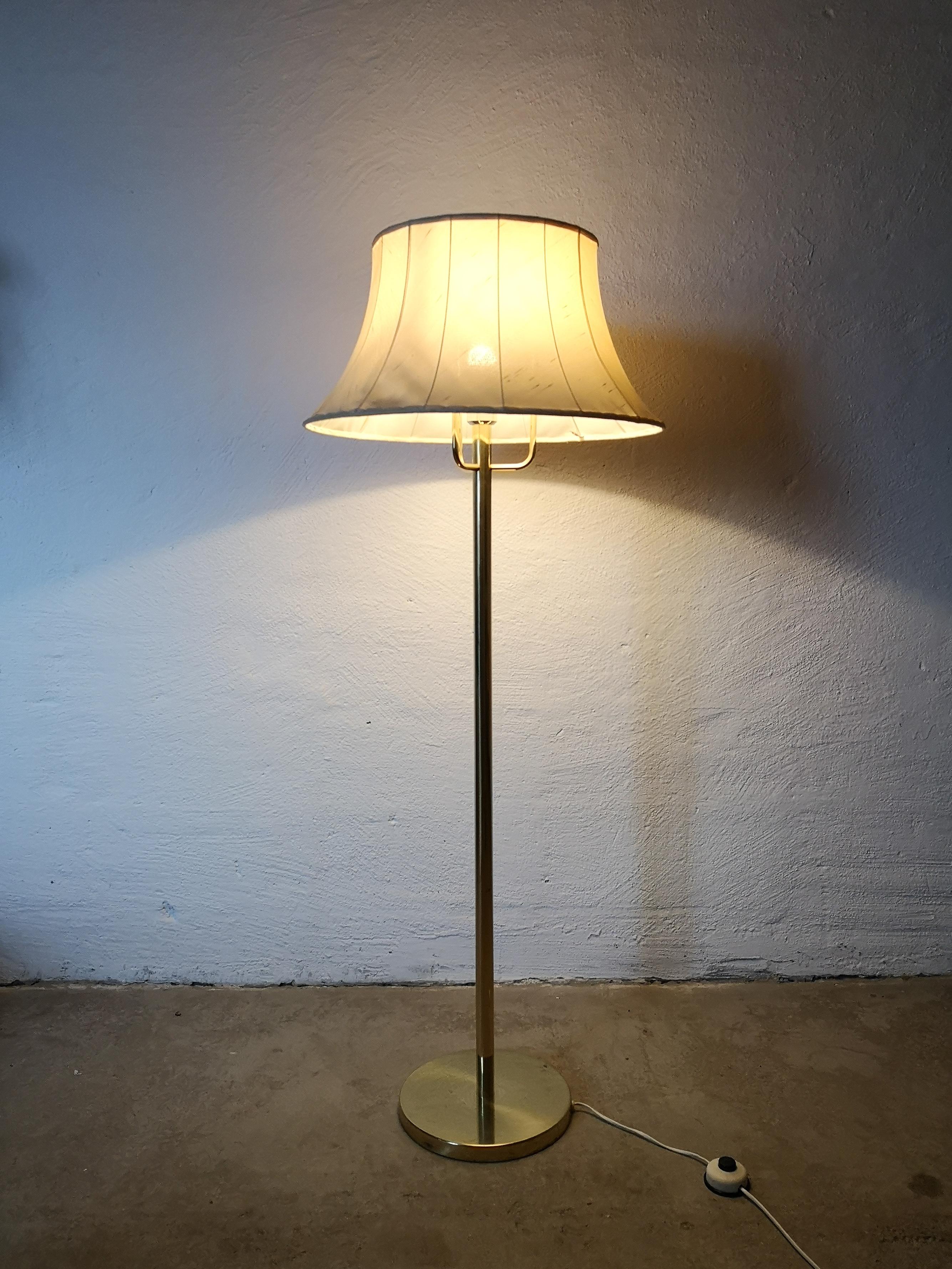 Floor lamp model G-199 designed by Hans-Agne Jakobsson. Solid Brass lamp with an original shade. 

The brass part of the lamp is in good condition with some scratches and wear of the age. The shades is in fair condition.

