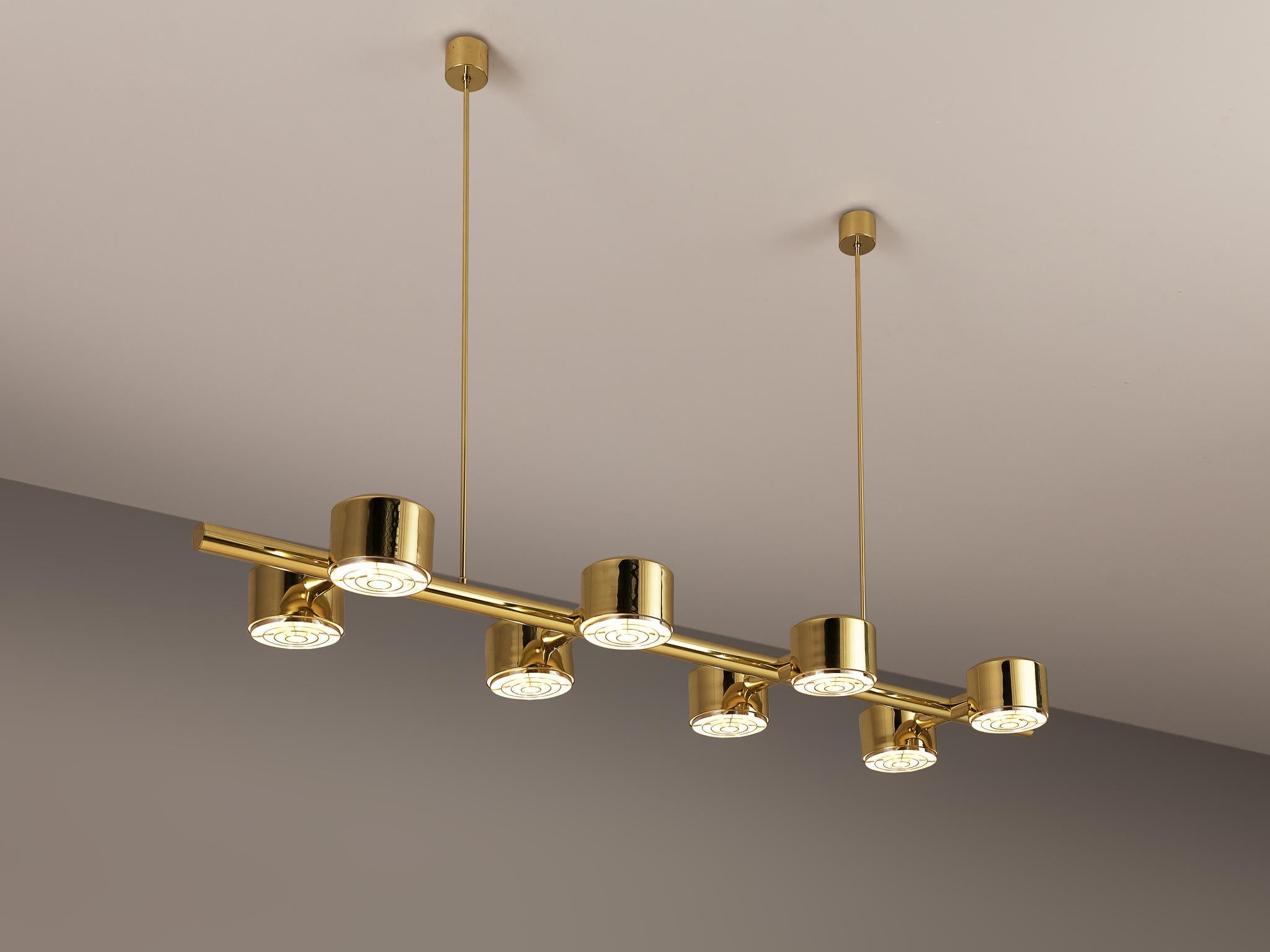 Hans-Agne Jakobsson for Hans-Agne Jakobsson AB in Markaryd, ceiling light, model T 746, brass, Sweden, 1960s 

Hans-Agne Jakobsson designed this large chandelier with eight cylindrical light bulbs paired on a line. The brass reflects the light