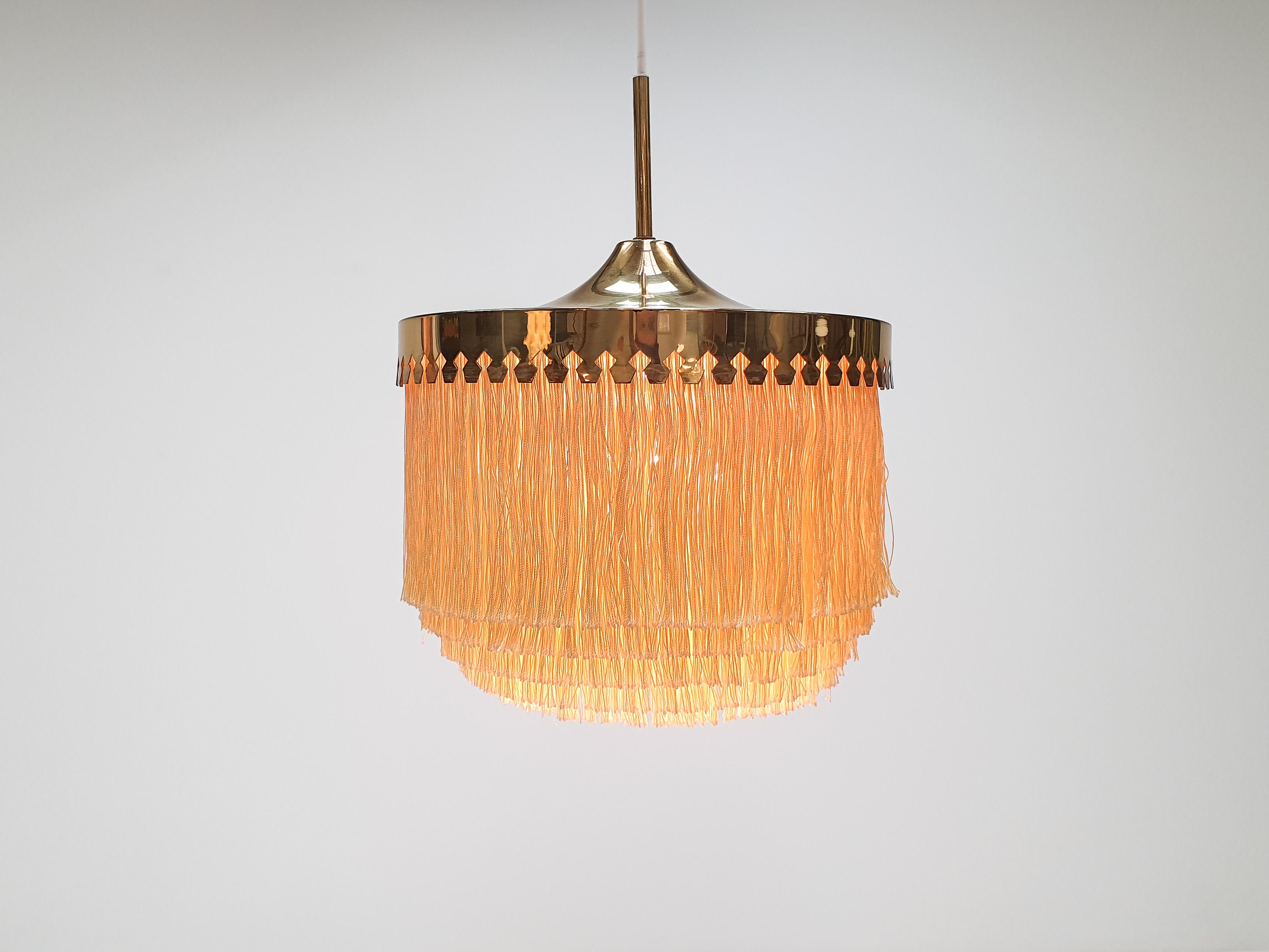A Hans-Agne Jakobsson for Markaryd brass and ivory silk fringe model T601/M pendant, 1960s
 
A Hans-Agne Jakobsson for Markaryd golden champagne coloured silk fringed pendant with brass frame, dating from the 1960s.
 
Fully working, rewired,