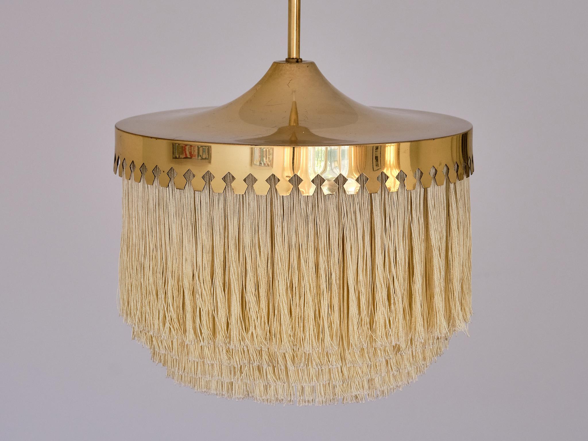 This striking pendant light was designed by Hans-Agne Jakobsson and produced by his company in Markaryd, Sweden in the 1960s. This model was numbered T601 and is part of his iconic fringe series.  

The design is marked by the brass fixture with its