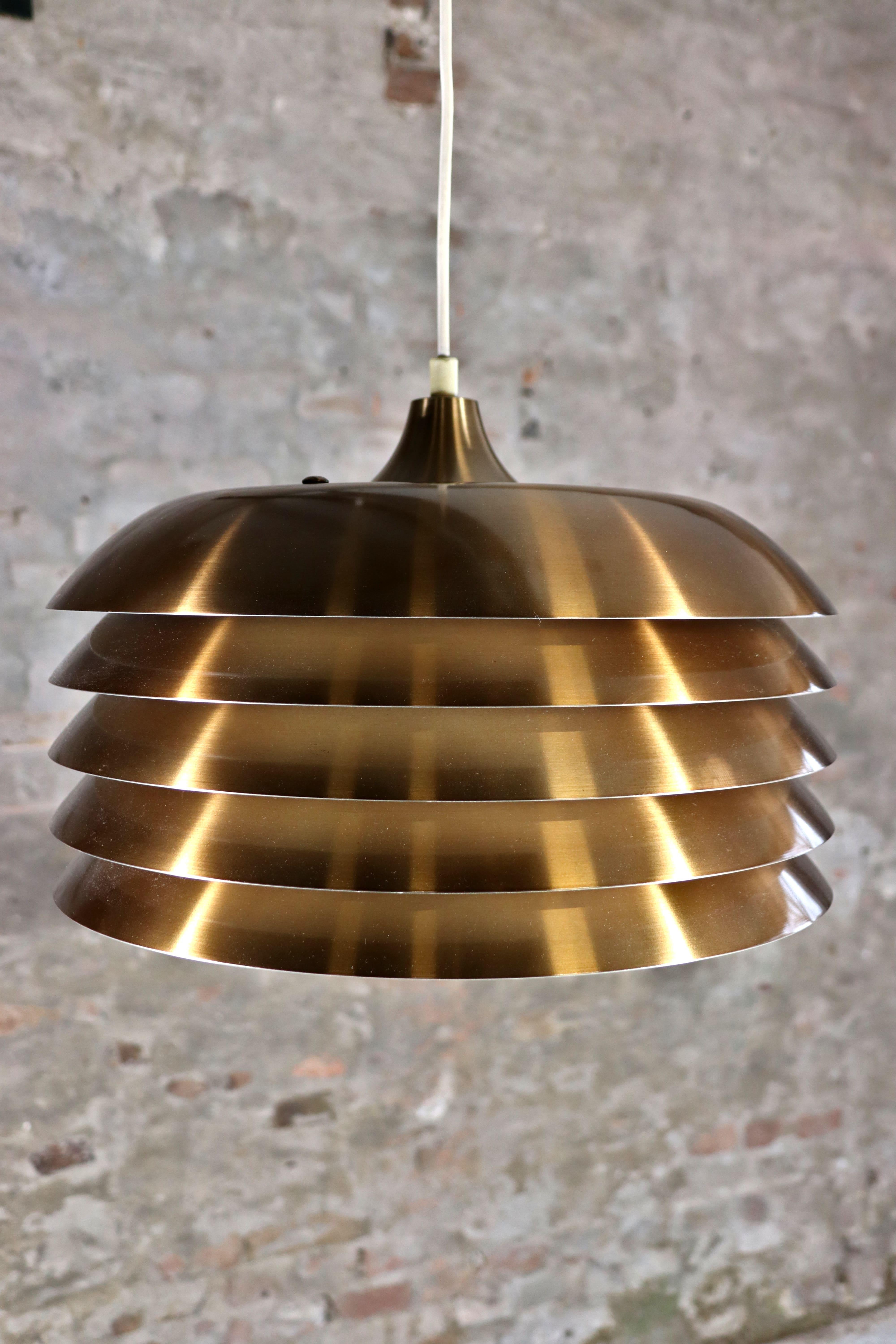 This beautiful lamp is called Lamingo and is designed by Hans-Agne Jakobsson. The lamp was made during the 1970s by Hans-Agne Jakobssons own company in Markaryd in  Sweden. It’s made of aluminum lamellas with brass lacquer on the outside and painted