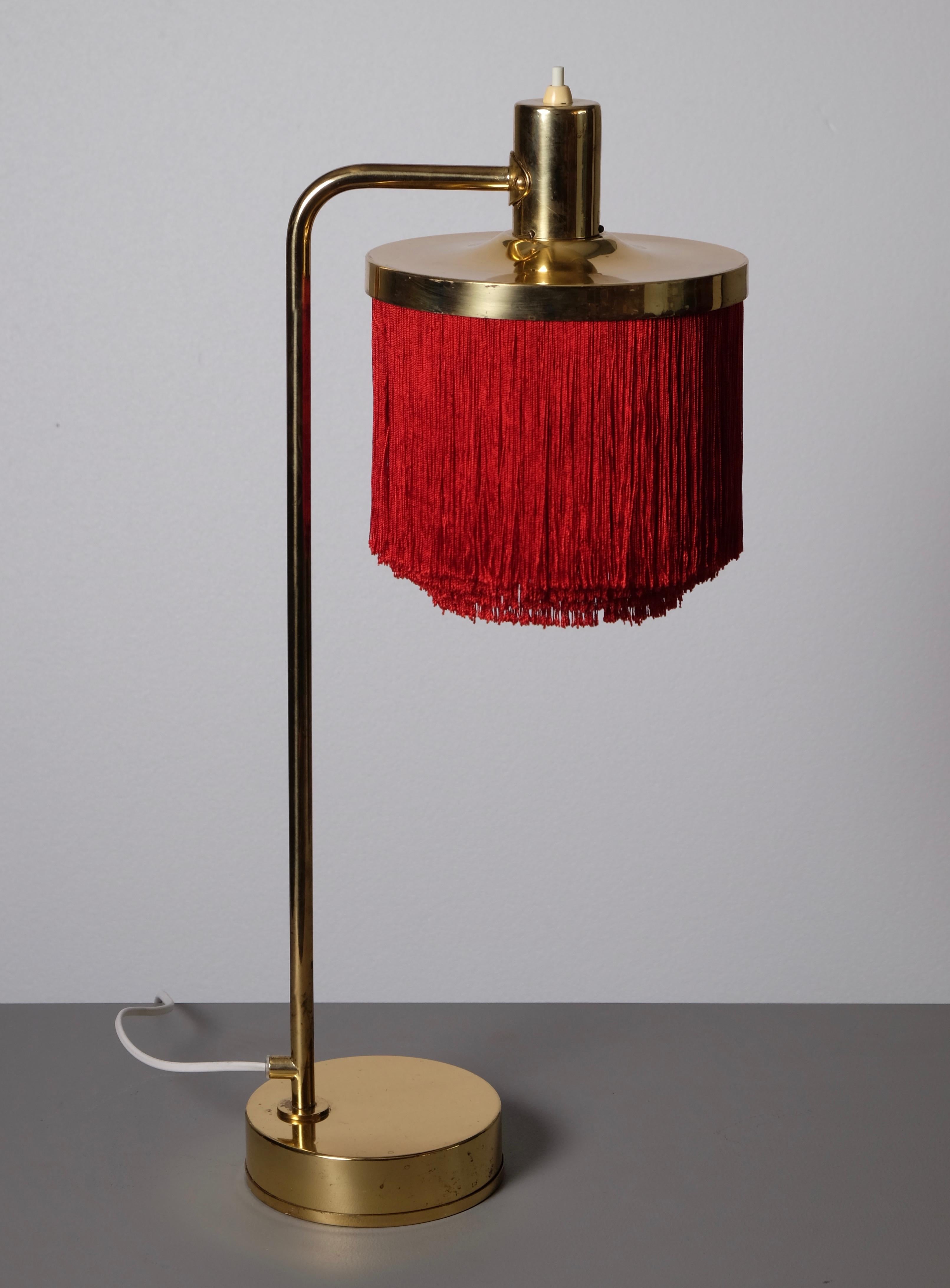 Tischlampe aus Messing mit roten Fransen, hergestellt von Hans-Agne Jakobsson in Markaryd, Schweden, 1960er Jahre.
Neue Verkabelung.