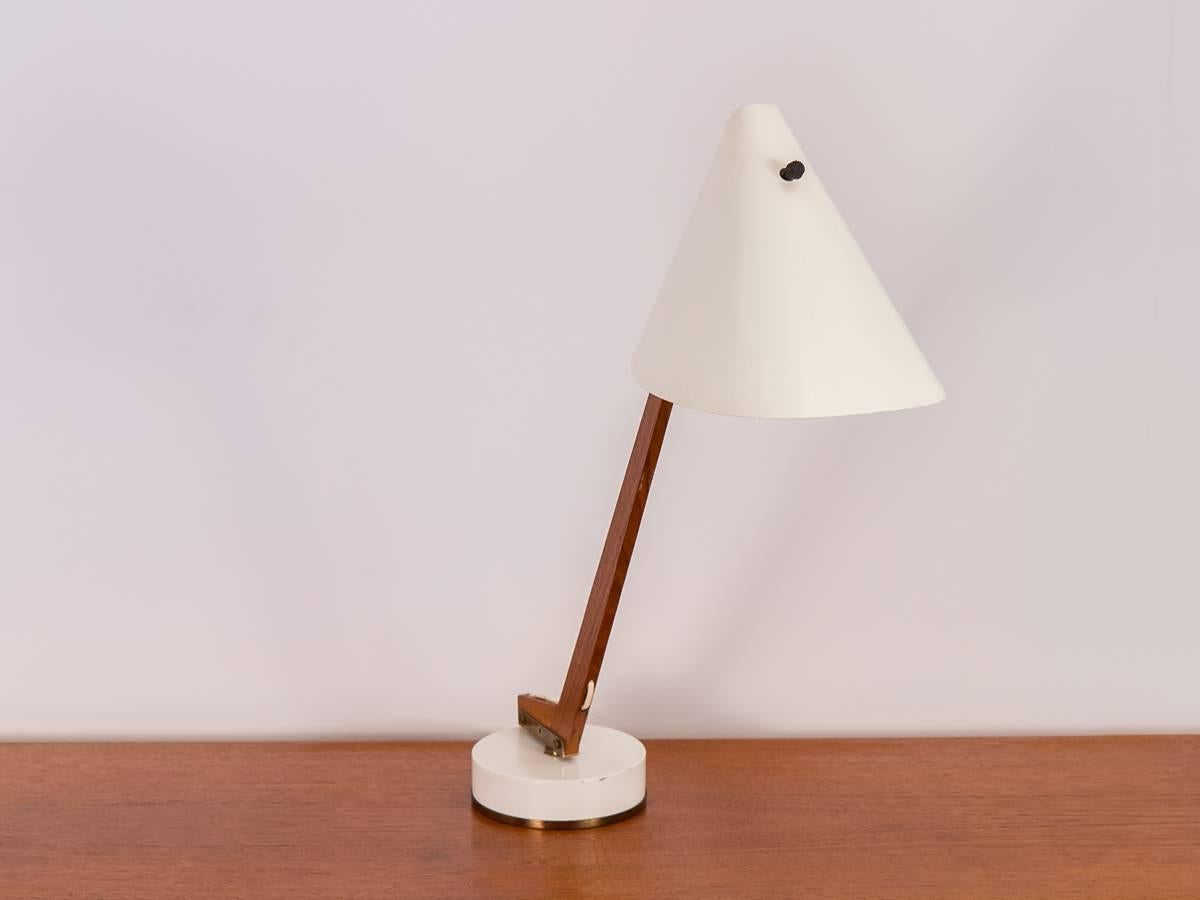 Model B-54 table lamp by Hans Agne Jakobsson for Markaryd. A gorgeous 1950s example of organic modern lighting design. Enamel hood and base are complimented by pretty brass details. Wire feeds through the slender teak neck, which fully swivels on