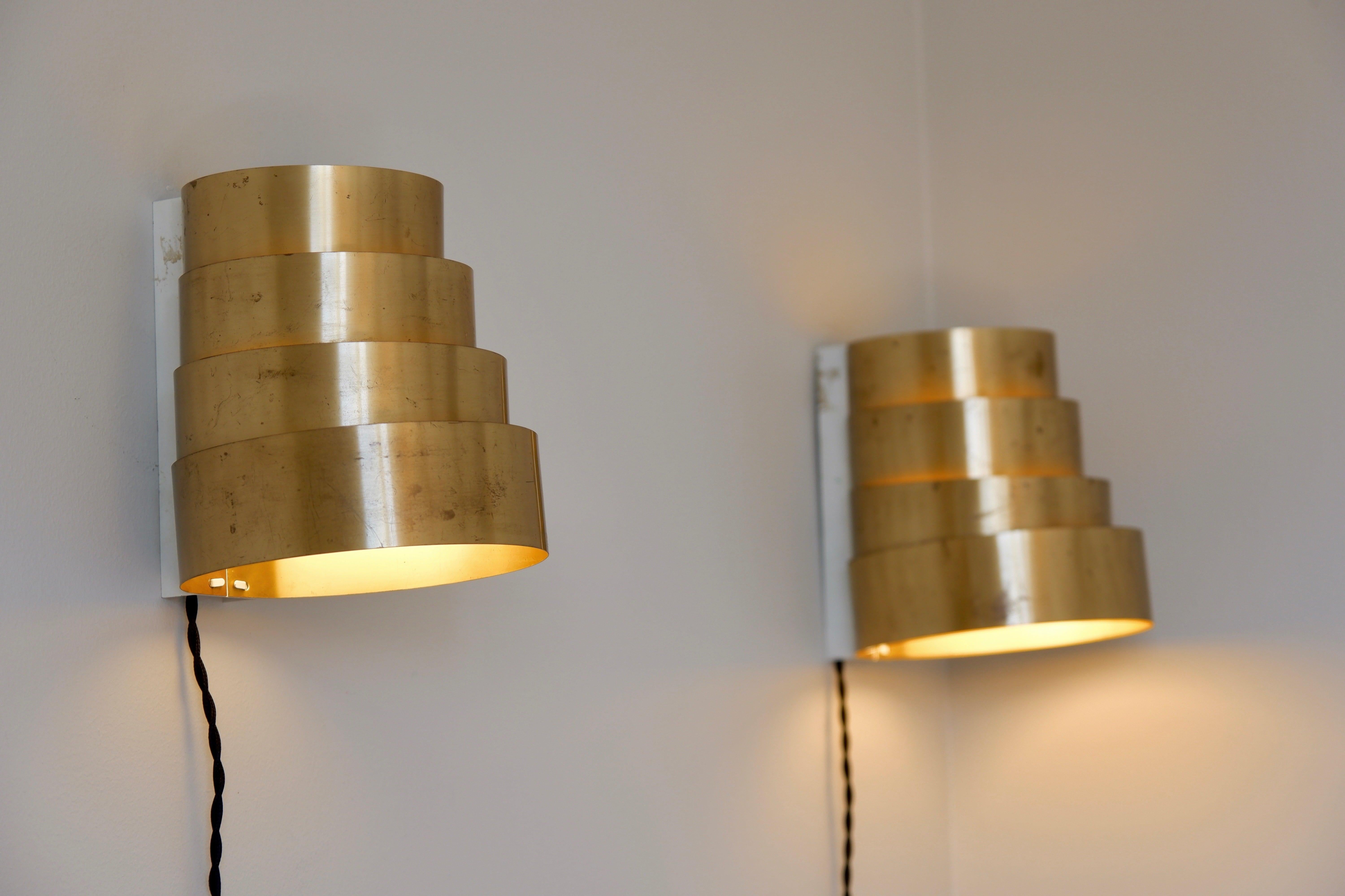 Rare paire d'appliques conçues par Hans Agnes Jakobsson à Design/One en Suède dans les années 60. Les deux lampes sont fabriquées en laiton massif avec 4 anneaux de laiton pour couvrir les bulles de lumière. L'état est agréable avec une bonne patine