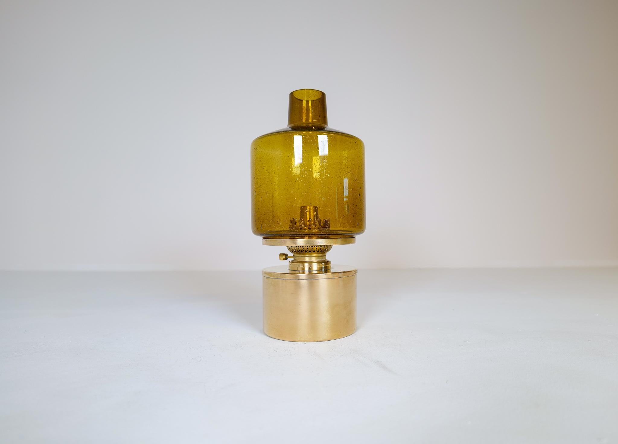 Lampe de table modèle lampe à huile modèle L-47 conçue par Hans-Agne Jakobsson. Produit par Hans-Agne Jakobsson à Markaryd, Suède. Verre soufflé à la main de couleur ambre. La pièce est composée d'une base en laiton poli et d'un verre. L'ensemble