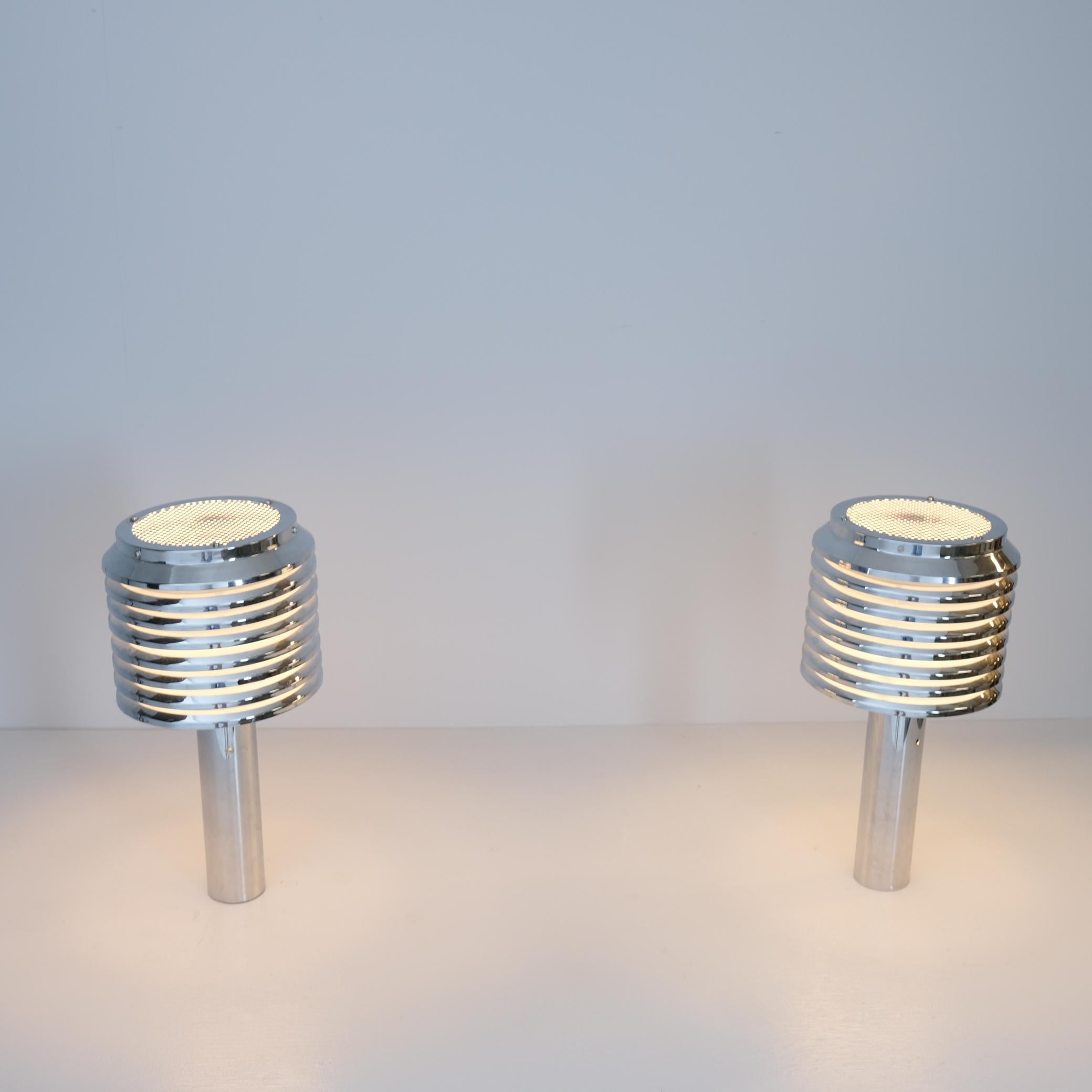 A beautiful pair of chrome table mounted lamps designed by Hans-Agne Jakobsson and manufatured by his own company in Markaryd Sweden in the 1970s. The lamps feature a full chromed frame with a layered shade casting a warm light evenly into the