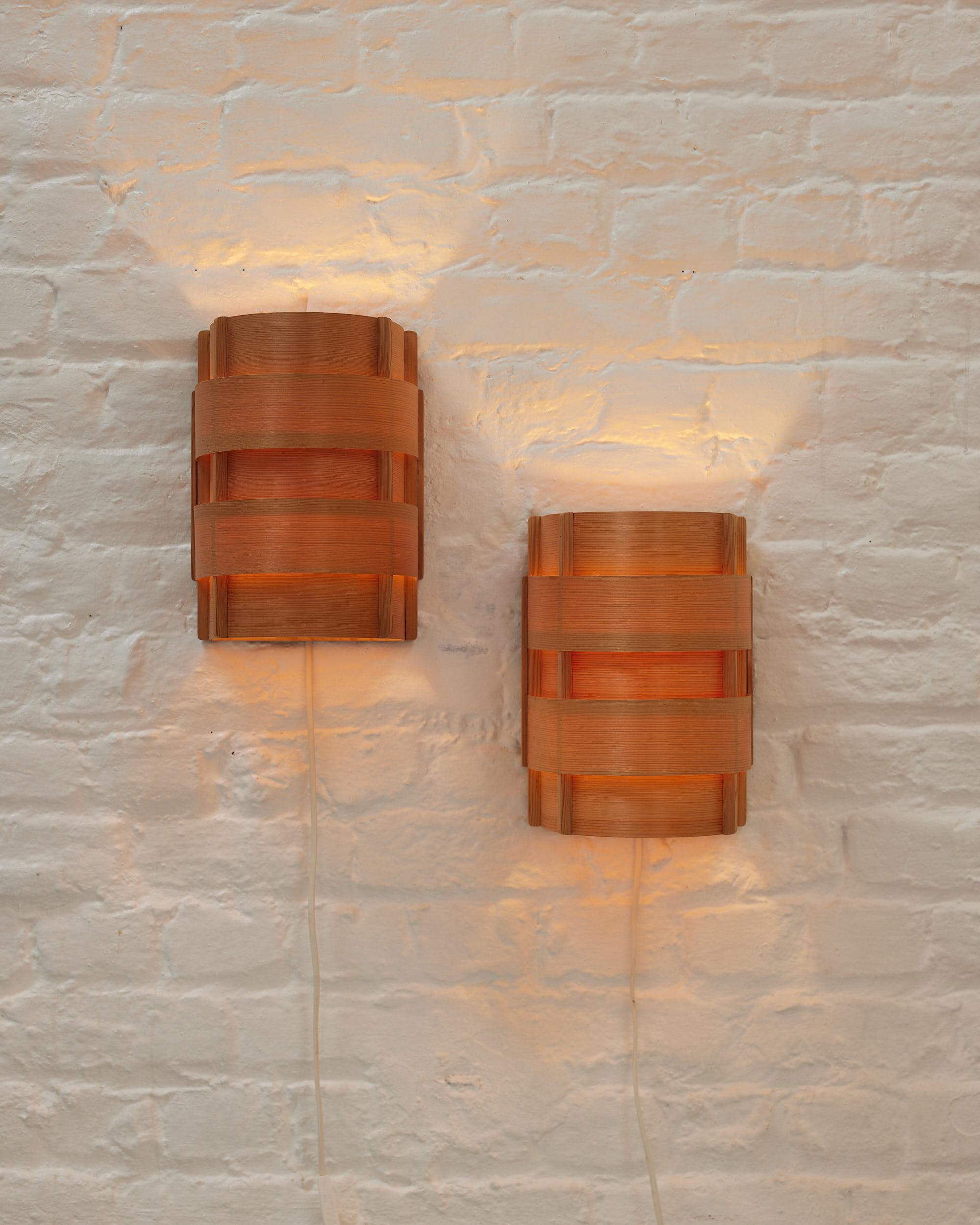Minimalistic Scandinavian wall lamps from 1950’s, designed by Hans Agne Jacobsen with the Ellysett
Markaryd label and known as the model «Edda». The lamps are made of neatly bent pine wood sheets and connected to a wooden frame. Transparent and warm