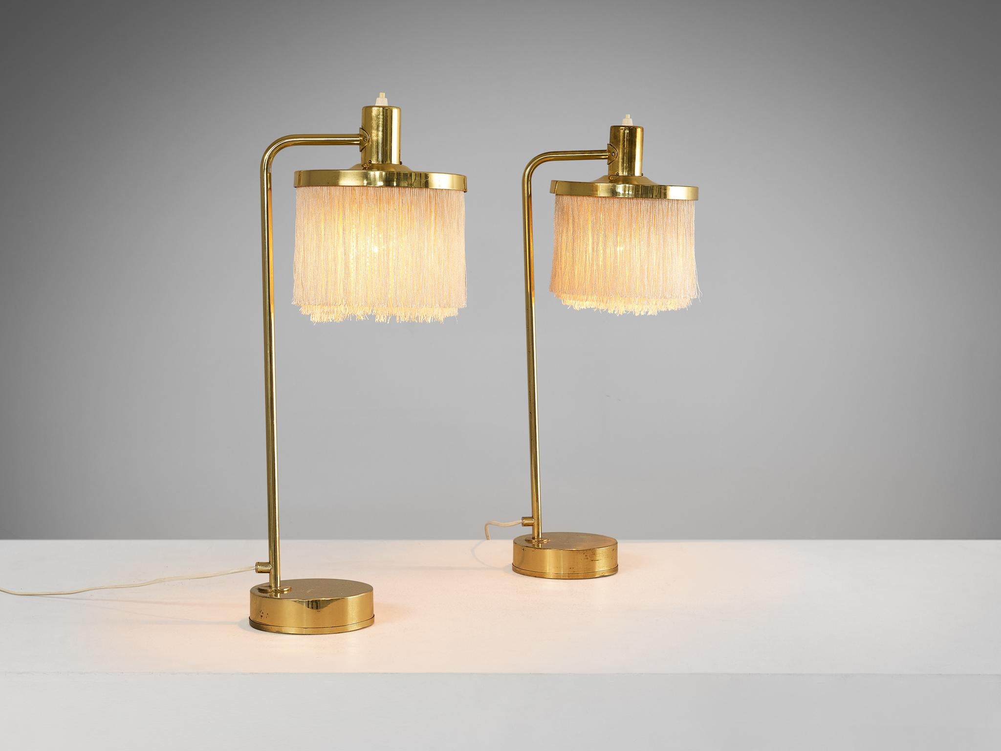Hans-Agne Jakobsson for Hans-Agne Jakobsson AB in Markaryd, Sweden, pair of 'Fringe' table lamps, model B-140, brass, silk, Sweden, 1960s 

These extravagant desk lights are composed of an elegant curved arm, which holds a pendant adorned with