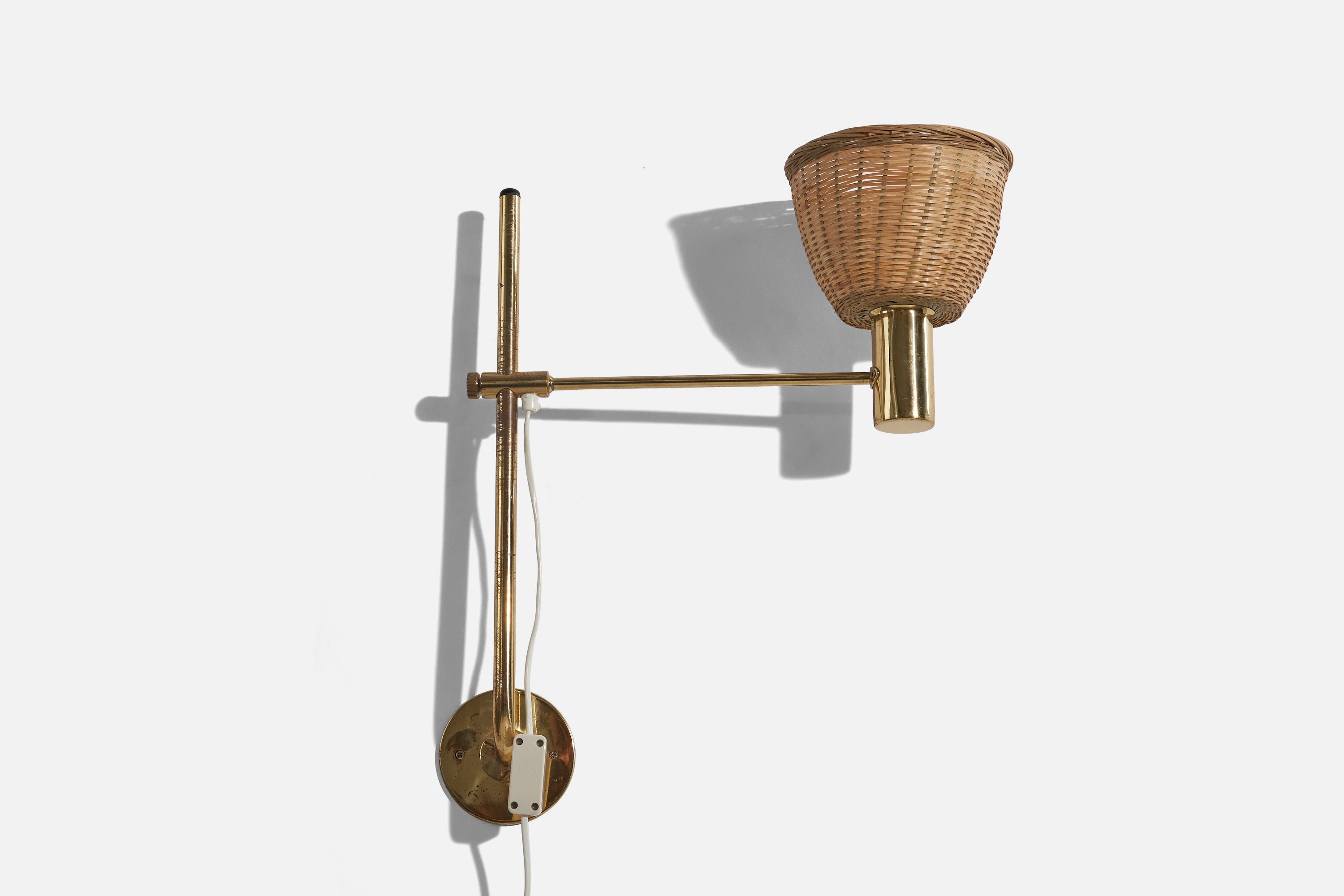 A pair of brass and rattan wall lights designed by Hans-Agne Jakobsson and produced by his own firm in Markaryd, Sweden. c. 1960s.

