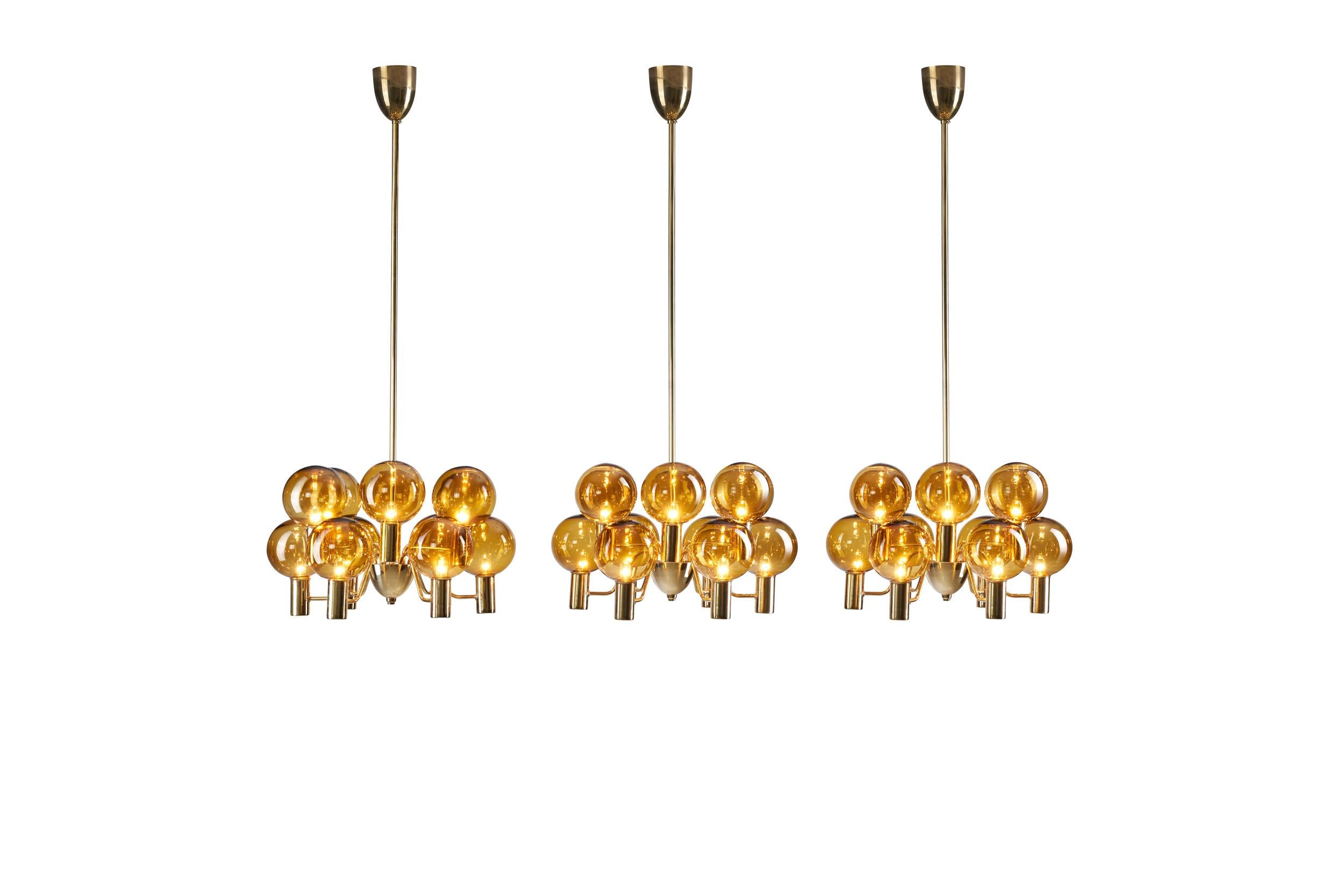 This set of stunning brass and glass “Patricia” chandeliers was created in what we now call “the golden age of Scandinavian design”. Hans-Agne Jakobsson created Swedish lighting models that still define the era, and this model is no
