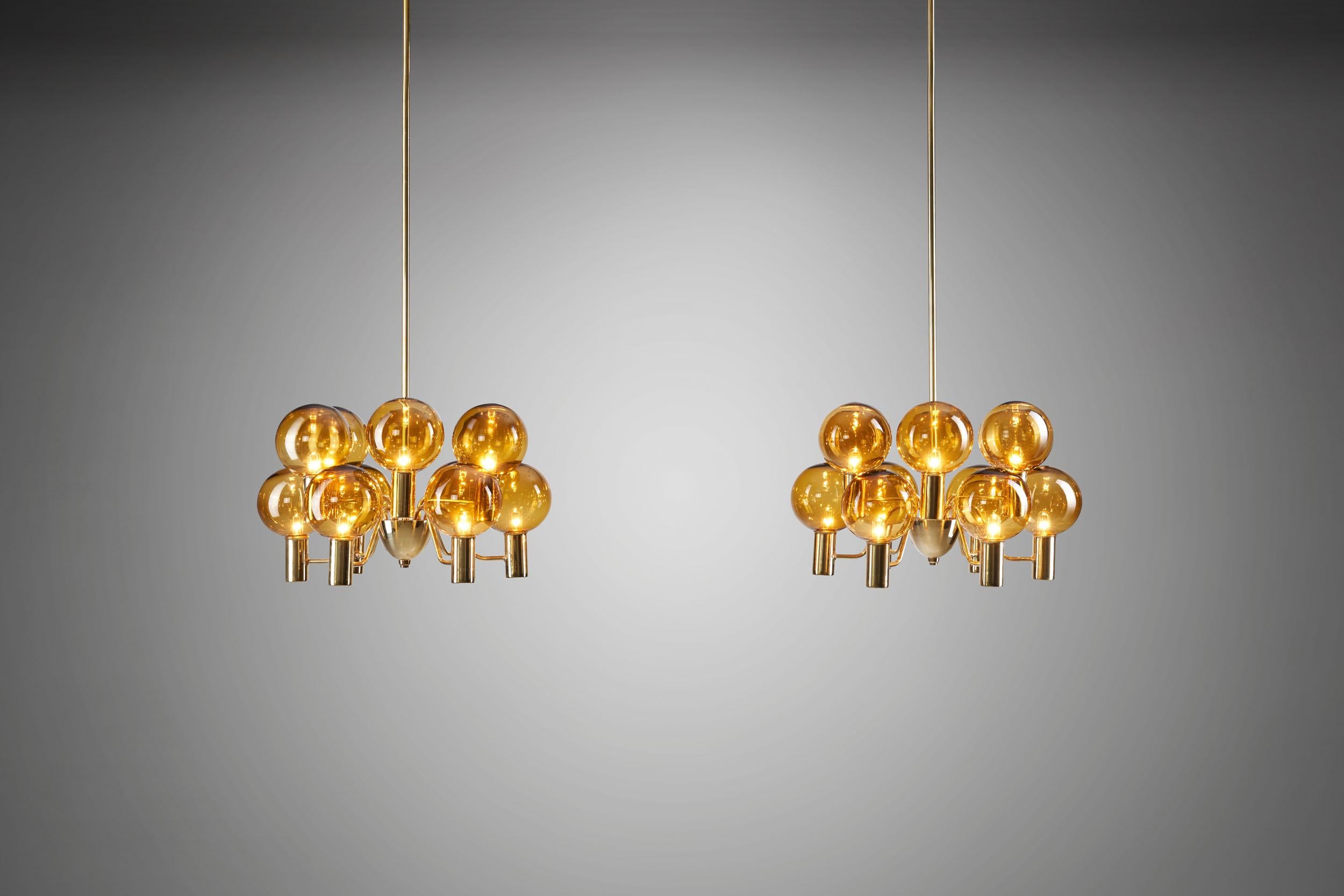 This pair of stunning brass and glass “Patricia” chandeliers was created in what we now call “the golden age of Scandinavian design”. Hans-Agne Jakobsson created Swedish lighting models that still define the era, and this model is no
