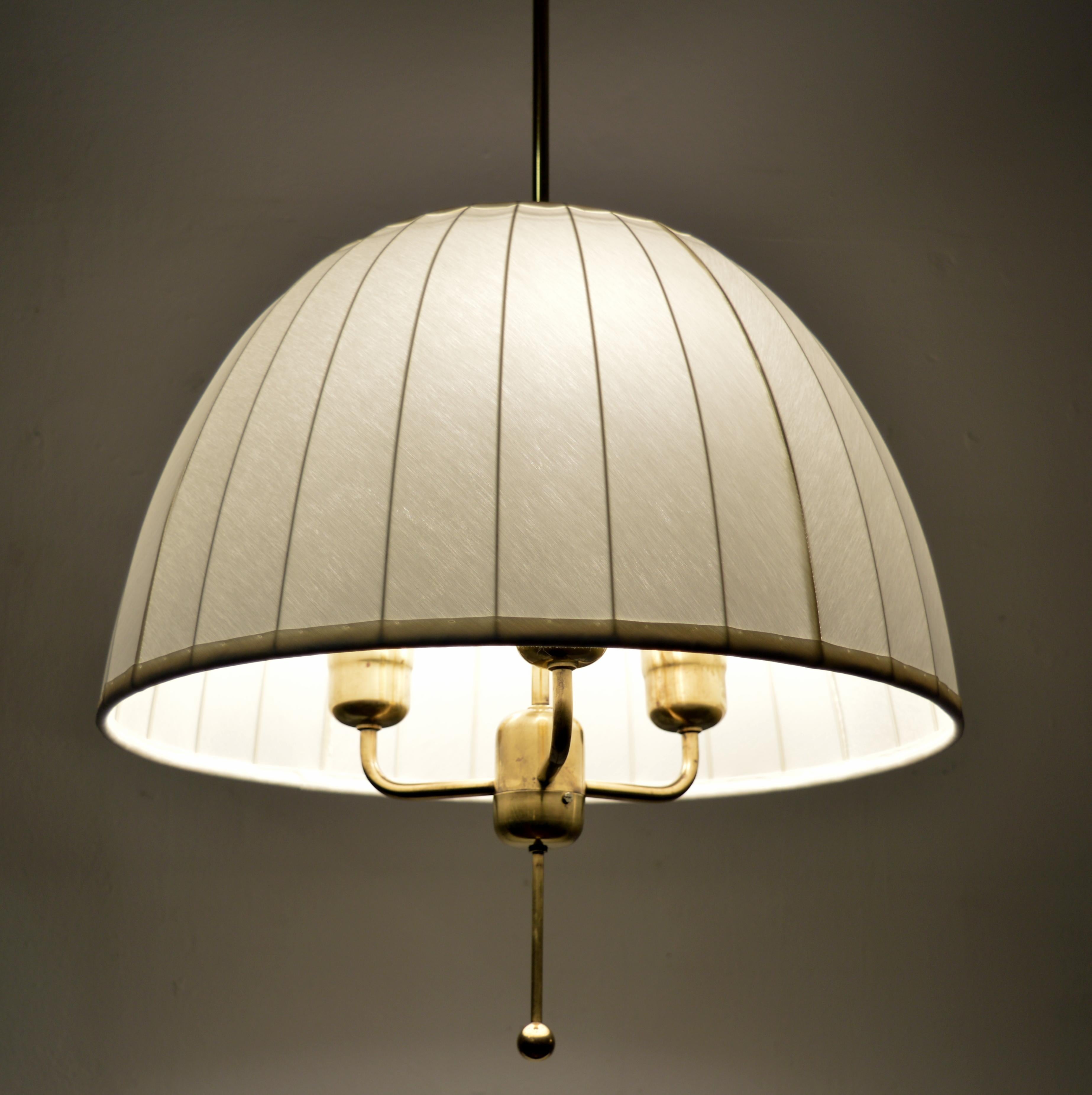 Splendida lampada a sospensione 'Caroline' modello T549/3 disegnata nel 1963 da Hans-Agne Jakobsson per la sua azienda di Markaryd, Svezia. Una struttura in ottone con un paralume originale appena rifatto in un bellissimo tessuto chintz bianco