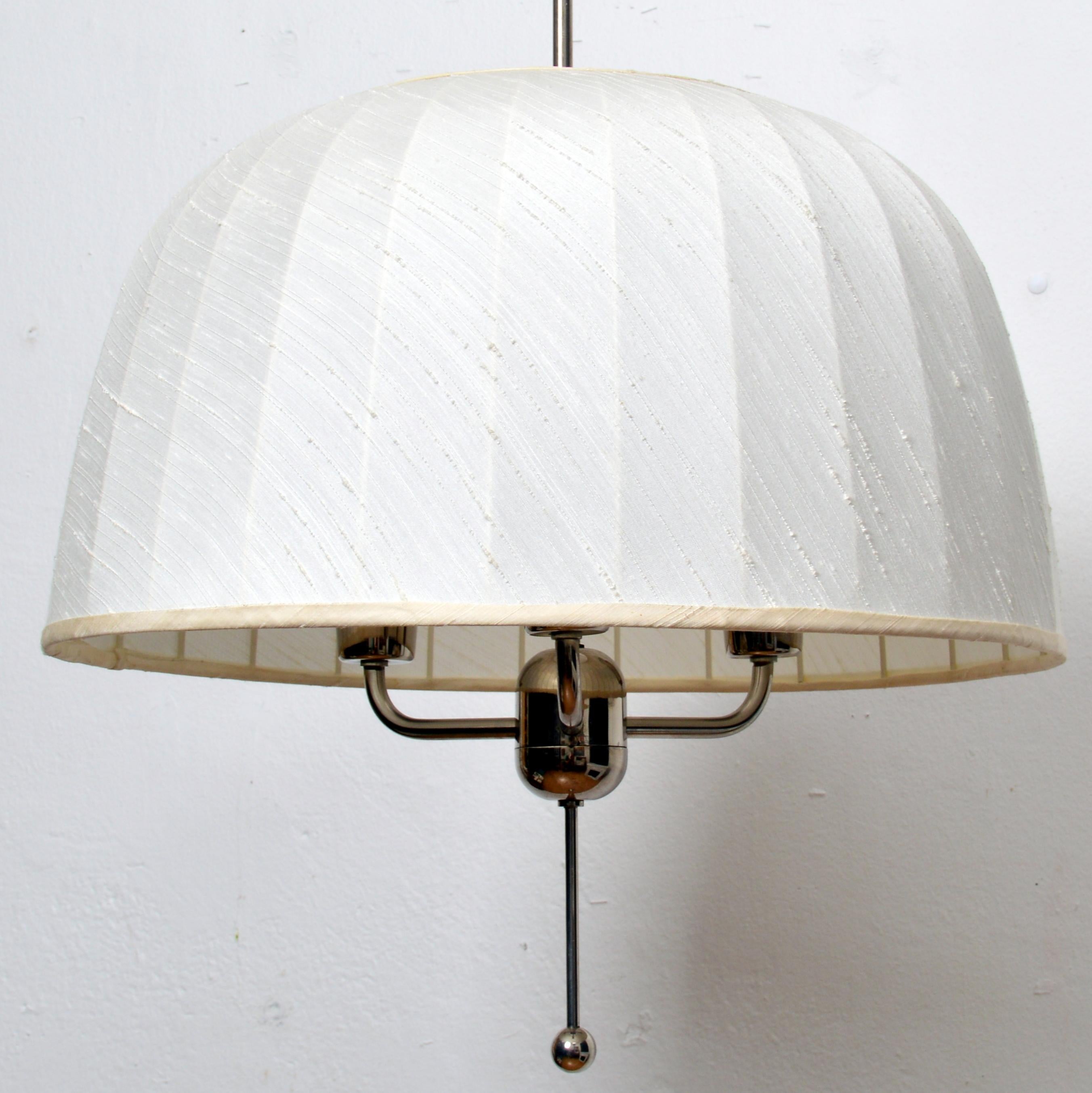 Splendida lampada a sospensione 'Caroline' modello T549/3 disegnata nel 1963 da Hans-Agne Jakobsson per la sua azienda di Markaryd, Svezia. Una cornice nichelata con un paralume originale con un bellissimo tessuto di seta tailandese bianco sporco in