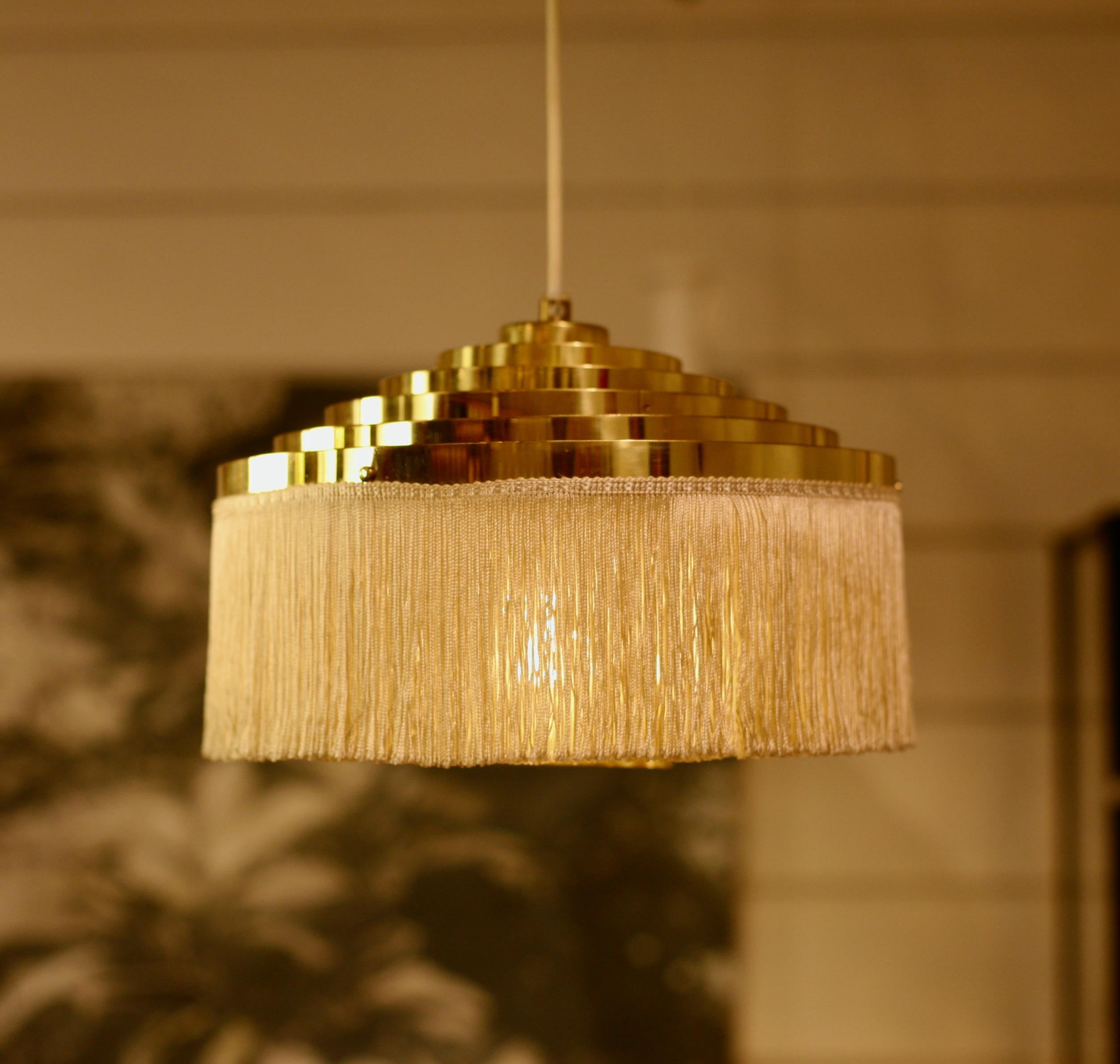 Brass fringe lamp designed by Hans-Agne Jakobsson in the 60´s and manufactured by his own factory. Silk fringes in an off-white color.