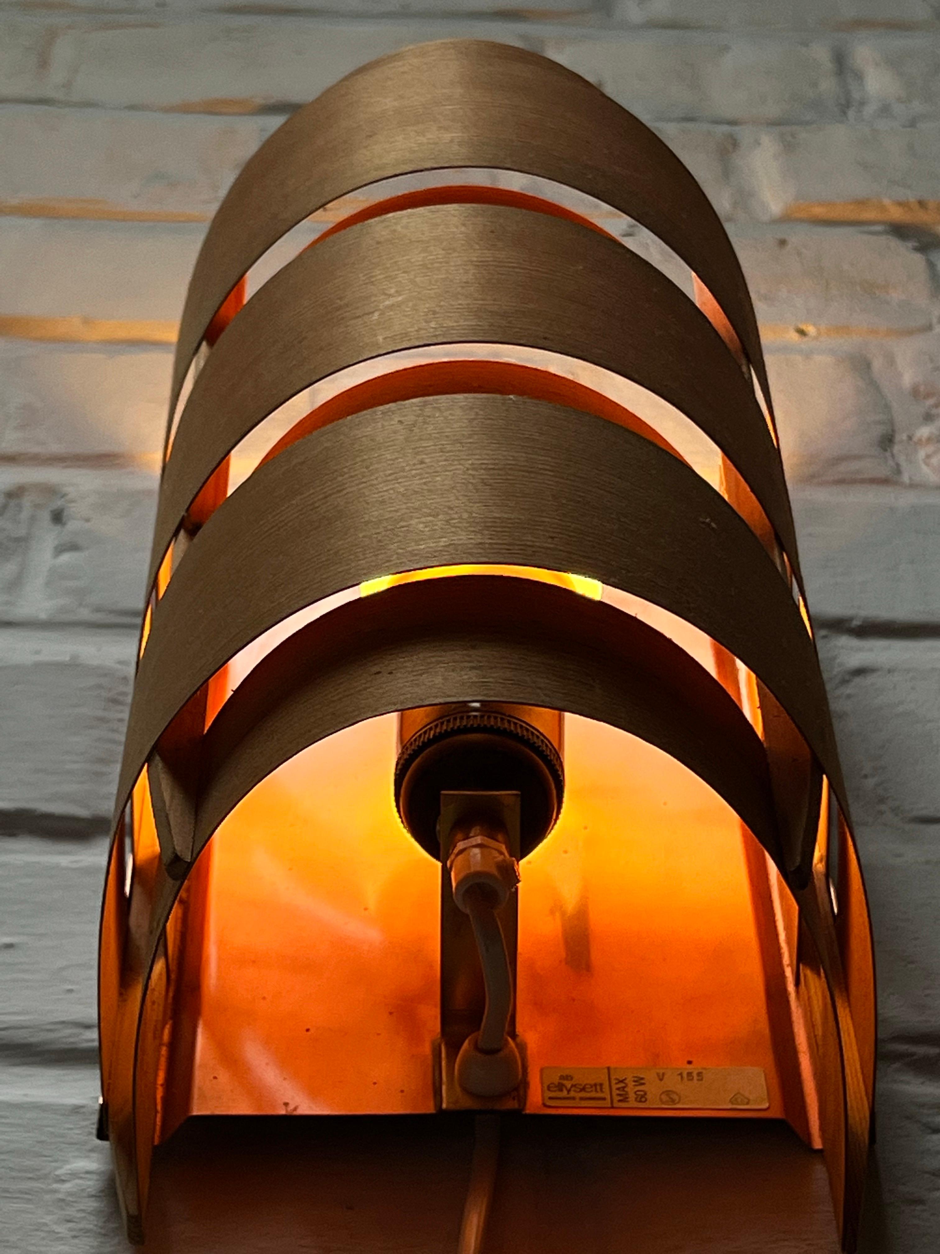 Bel set di 4 lampade da parete in pino e rame. Offrono un'atmosfera calda e ancora più bella se illuminati. Realizzato con sottili strisce di pino delicatamente inchiodate con un chiodo di ottone alla lastra di rame che costituisce il retro e i