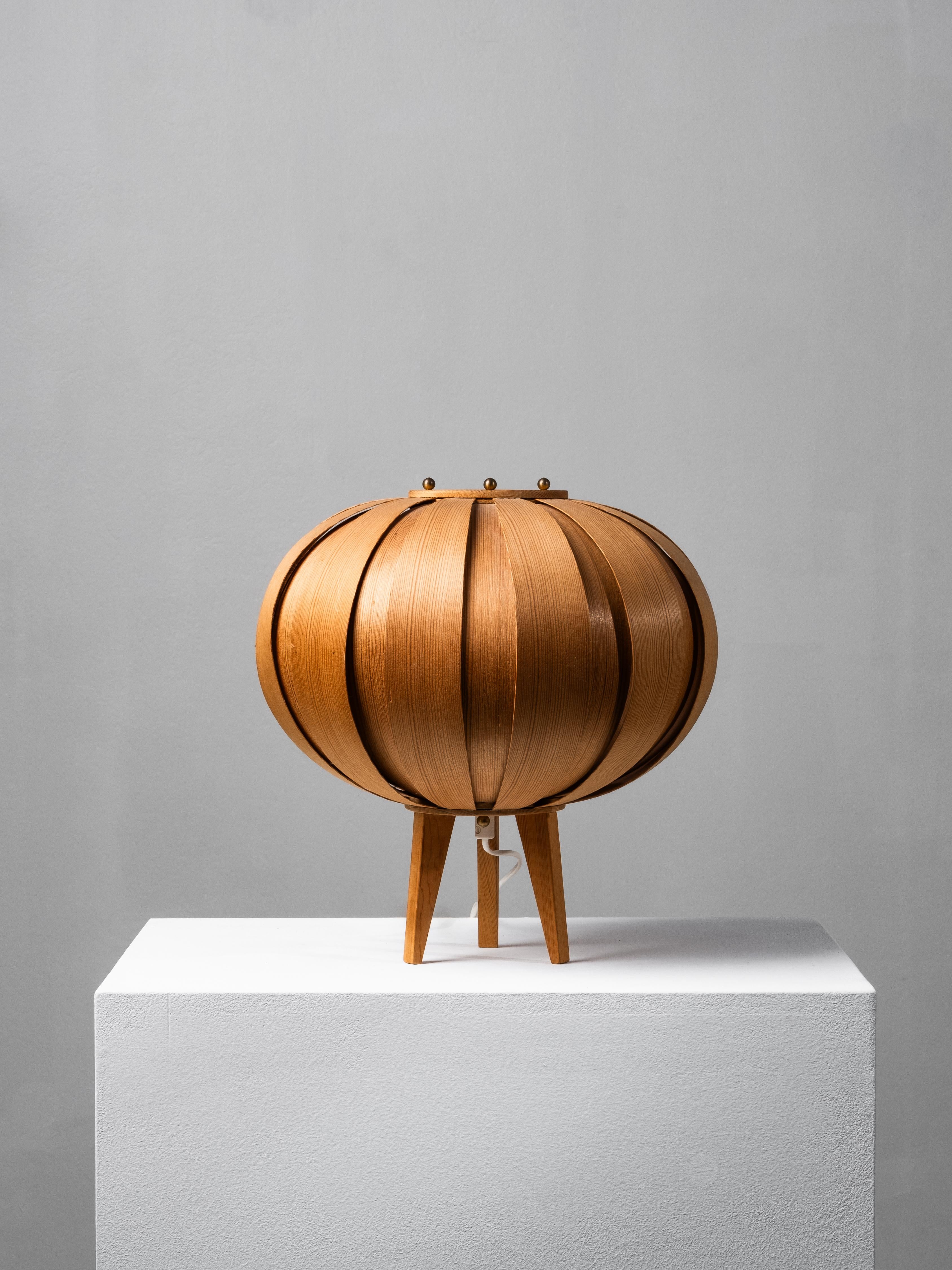 Rare pine bentwood table lamp designed by Hans-Agne Jakobsson for AB Ellysett in Markaryd, Sweden, 1960s.

The lamp features Jakobsson’s signature construction of thin, curved pinewood slats arranged in a rounded, lantern-like form on a three-legged