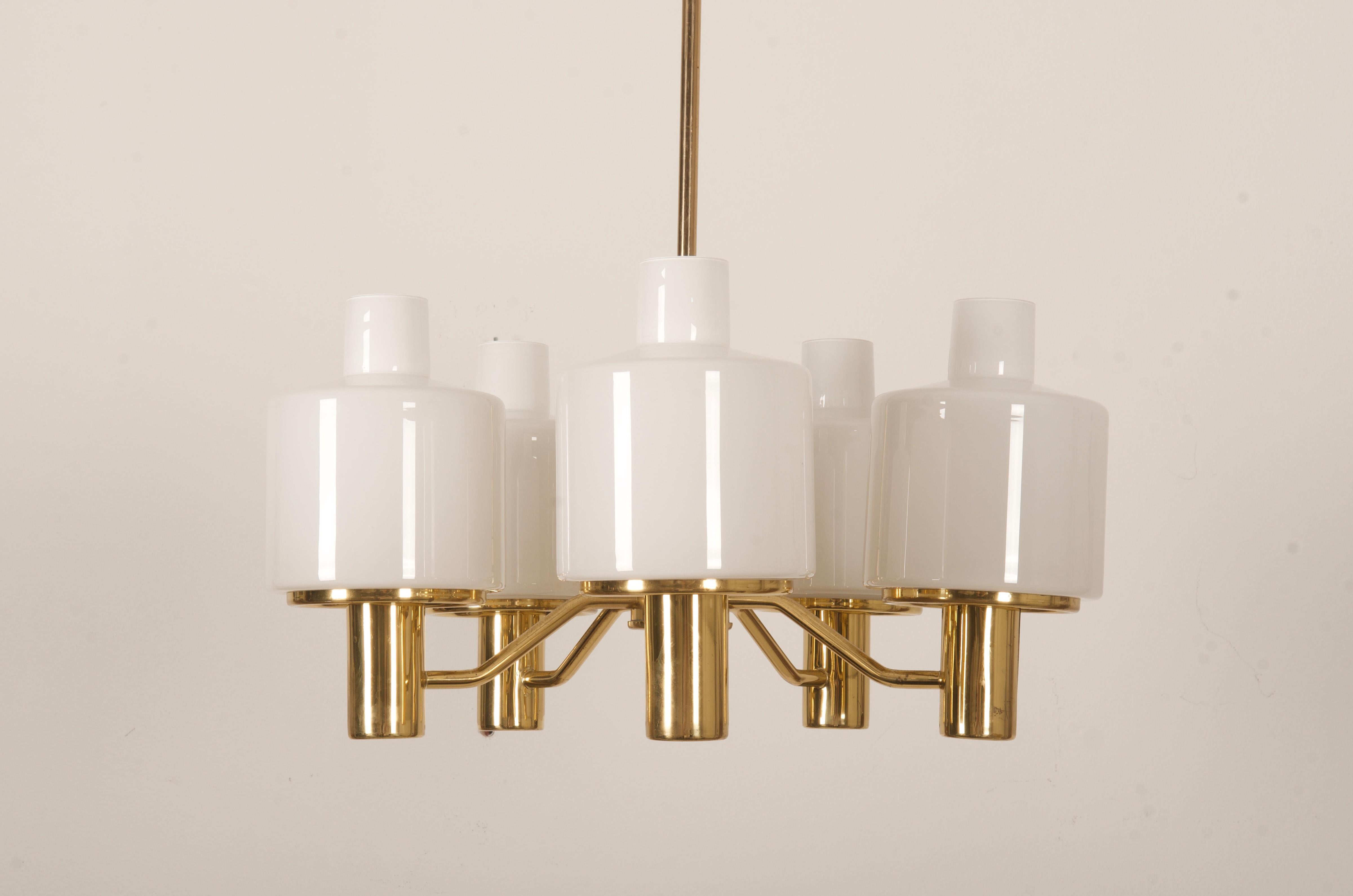 Brass frame with 6 arms fitted each with E27 sockets and opaline glass shades ( on request also smoked glass). Designed by Hans-Agne Jakobsson in the 1960s in Sweden, model 