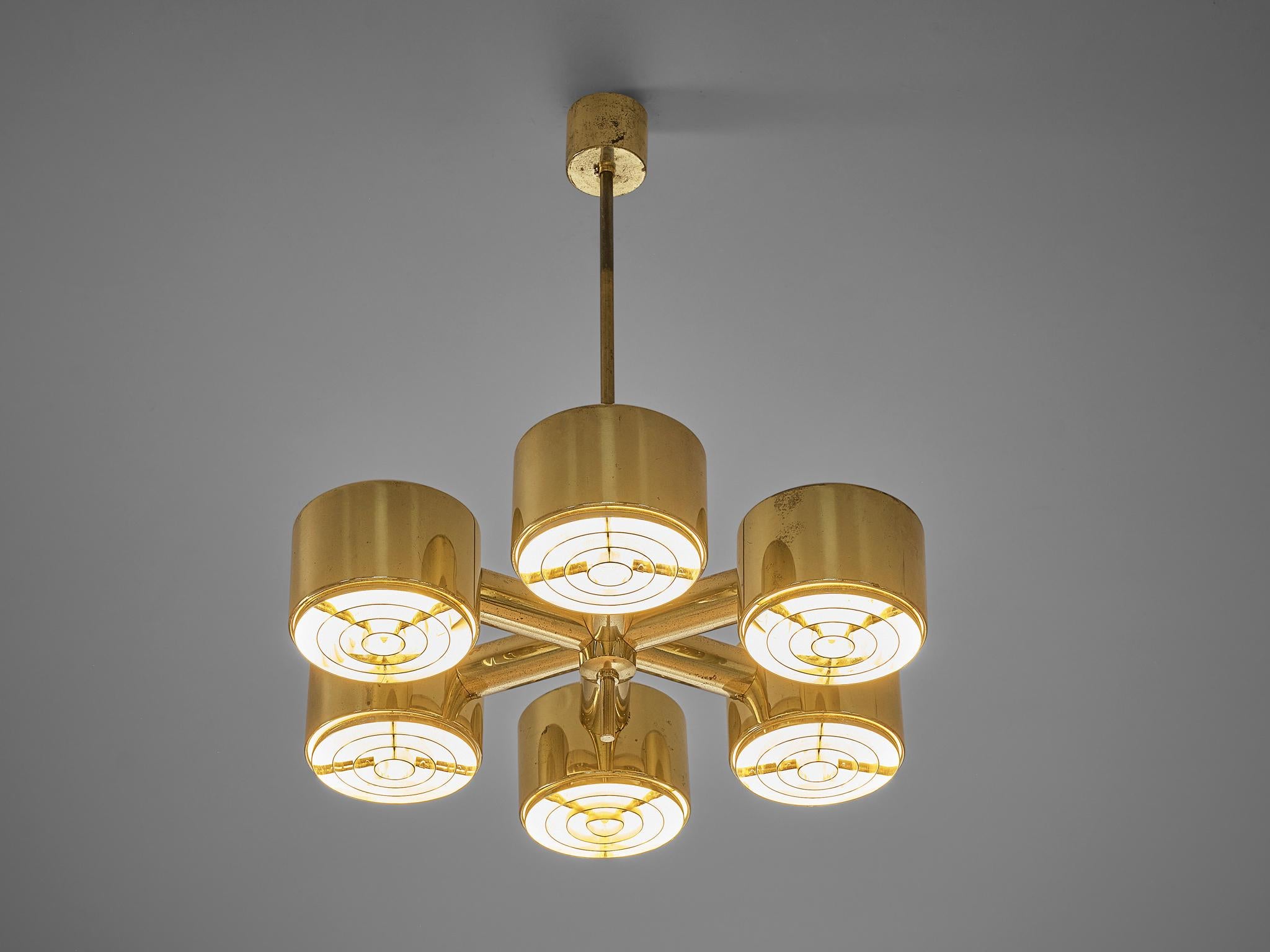 Hans-Agne Jakobsson for Hans-Agne Jakobsson AB in Markaryd, brass, plastic, Sweden, 1960s 

This stunning chandelier is designed by the Swedish designer Hans-Agne Jakobsson. It features six cylindrical shades which are attached on a frame creating