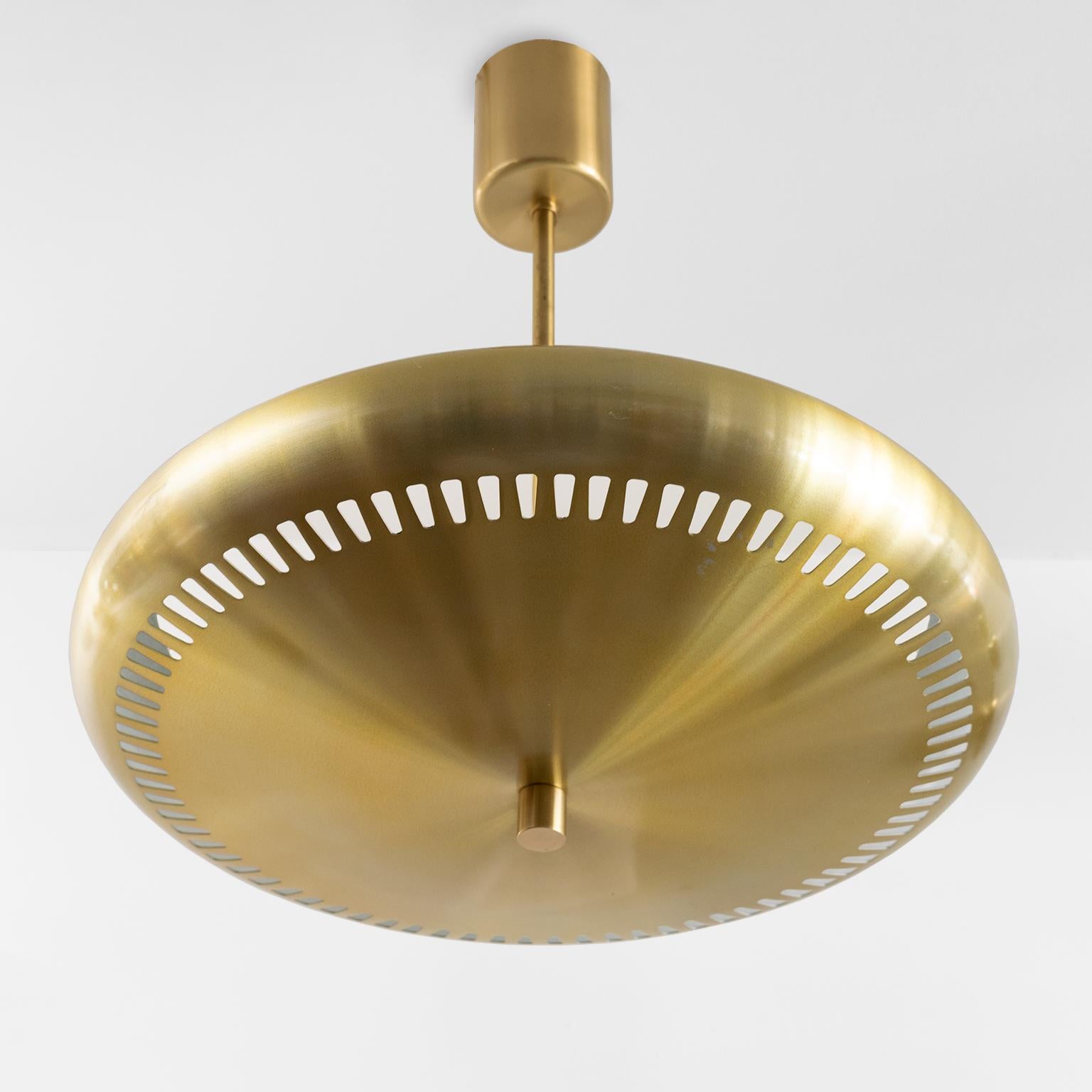 One of two available Scandinavian Modern uplight pendants designed by Hans-Agne Jakobsson for Luxus, Sweden. The fixture’s shade is made from lightweight aluminum and is plated in brass, the stem, canopy and finial are all brass. Newly rewired with