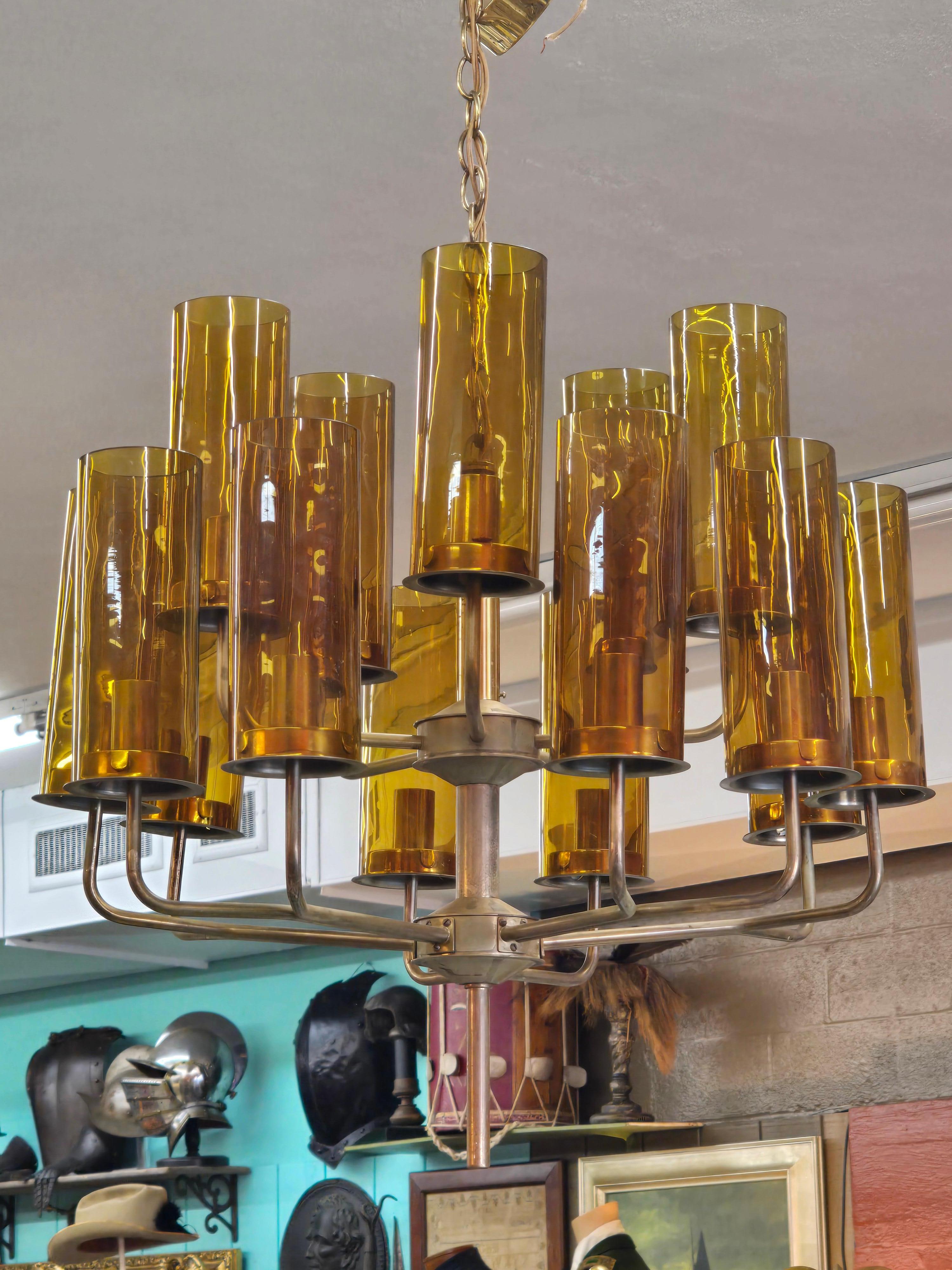 Struttura in ottone con 15 luci ciascuna con paralumi tubolari in vetro soffiato color ambra scuro.  Mod T-434/15 Sonata, progettato da Hans-Agne Jakobsson per AB Markaryd, Svezia, anni '60.  Il lampadario si presenta come nuovo con la finitura