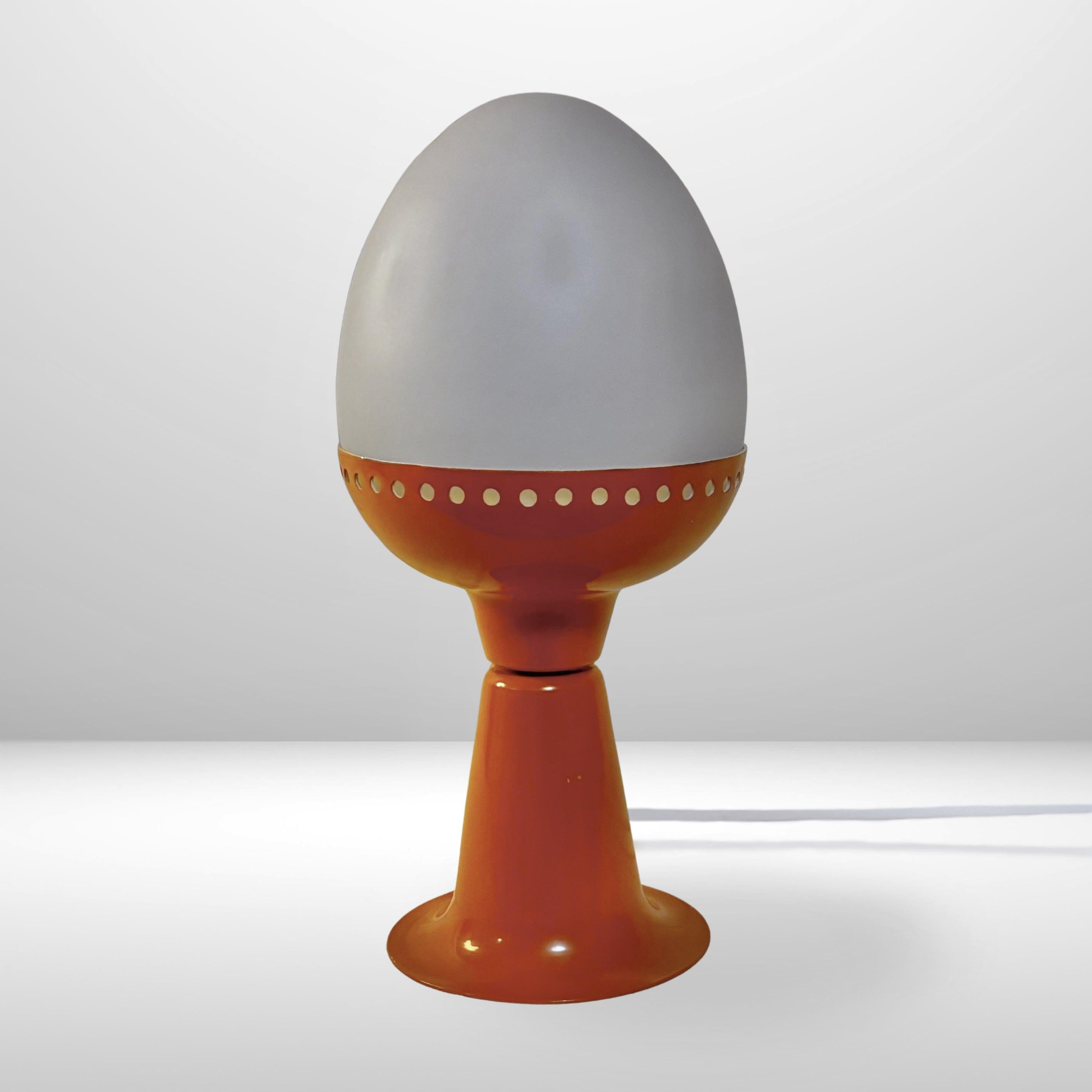 Petite lampe de table futuriste, modèle B225, conçue et produite par Hans-Agne Agnes dans les années 1960. Elle se compose d'une base en aluminium orange et d'un abat-jour en verre opalin en forme d'œuf. Le pied tulipe et le métal perforé donnent à