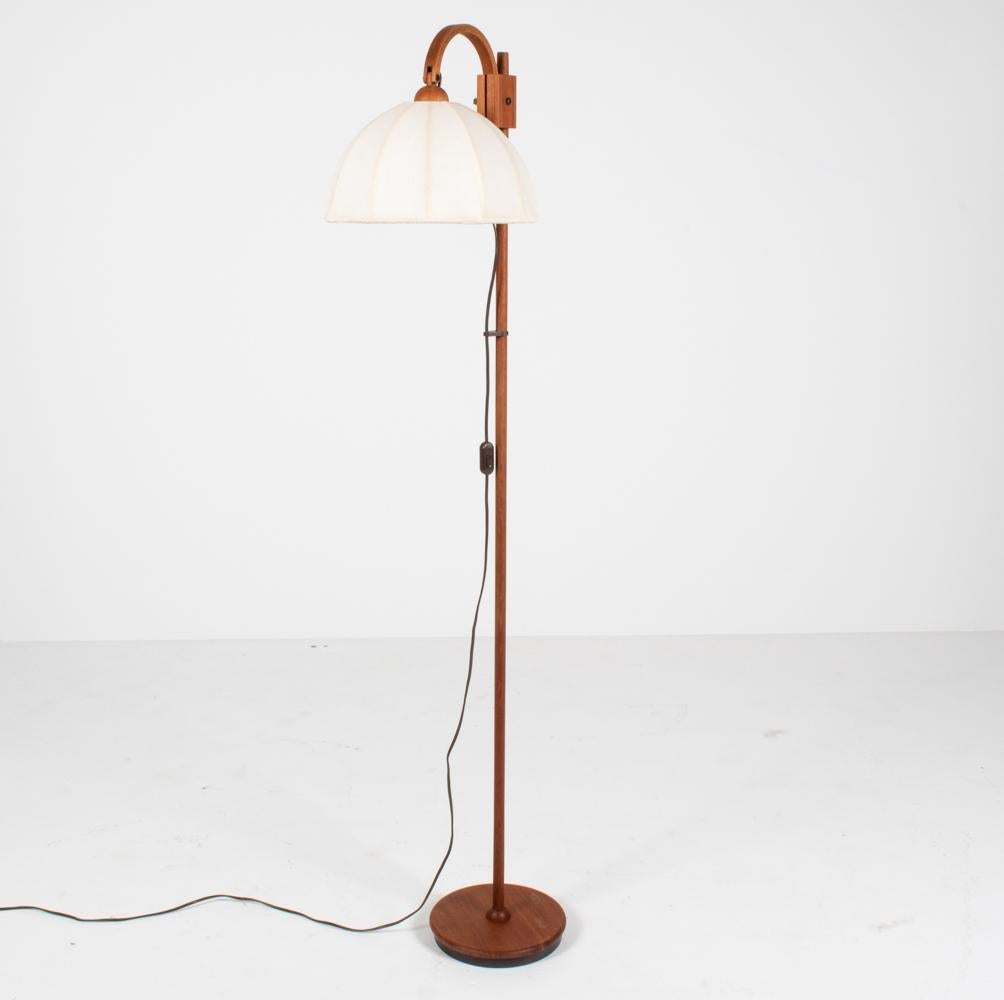 This stylish mid-century floor lamp is in the manner of renowned Swedish interior and furniture designer Hans-Agne Jakobsson, most famous for his lighting designs, marked by their warm glowing light and organic-inspired forms. Born of the same vein