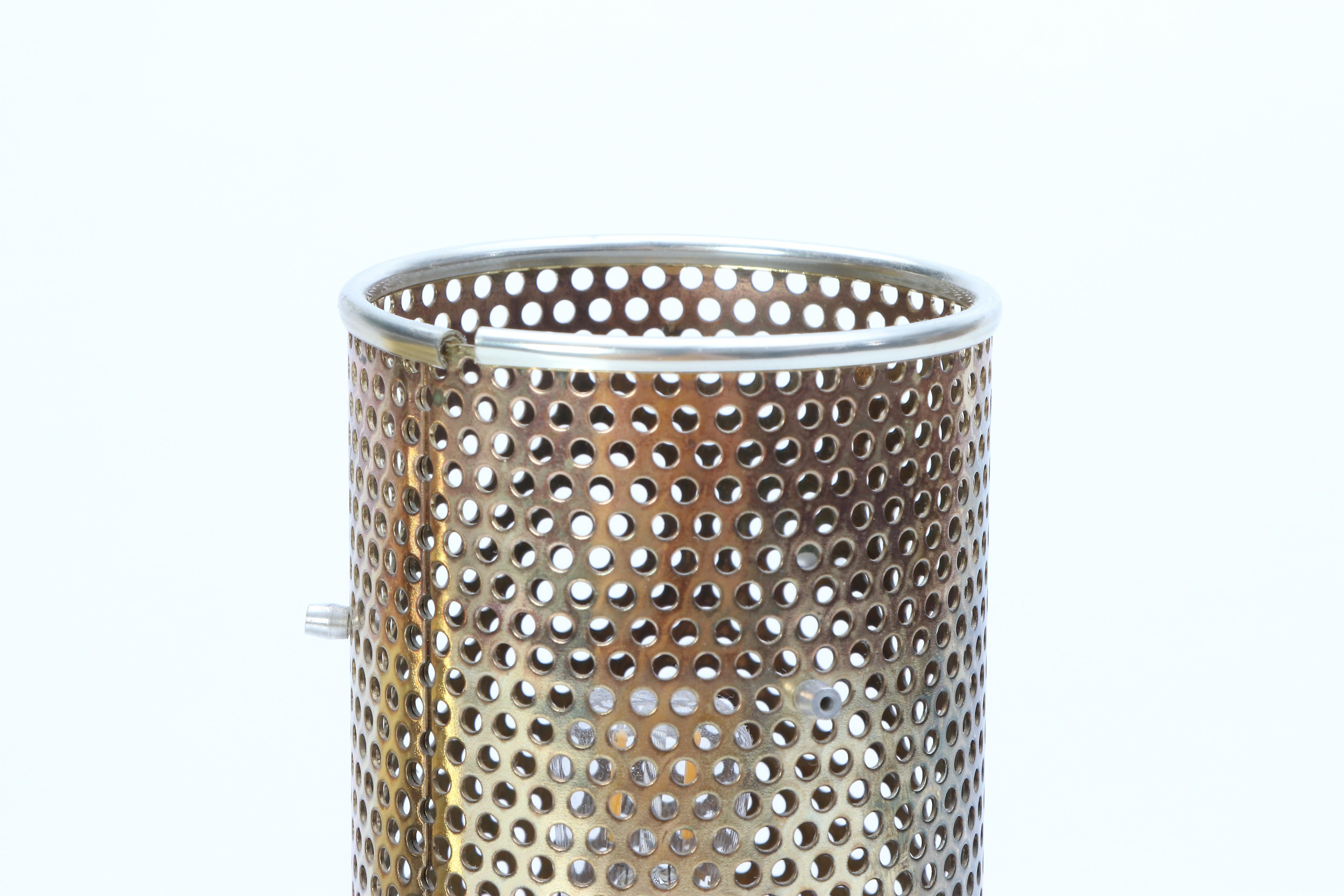 Lampada da tavolo minimalista disegnata da Hans-Agne Jakobsson negli anni '60 e prodotta a Markaryd in Svezia, modello B202. La lampada è composta da un paralume in ottone massiccio e da un'anima perforata in alluminio. La lampada è timbrata