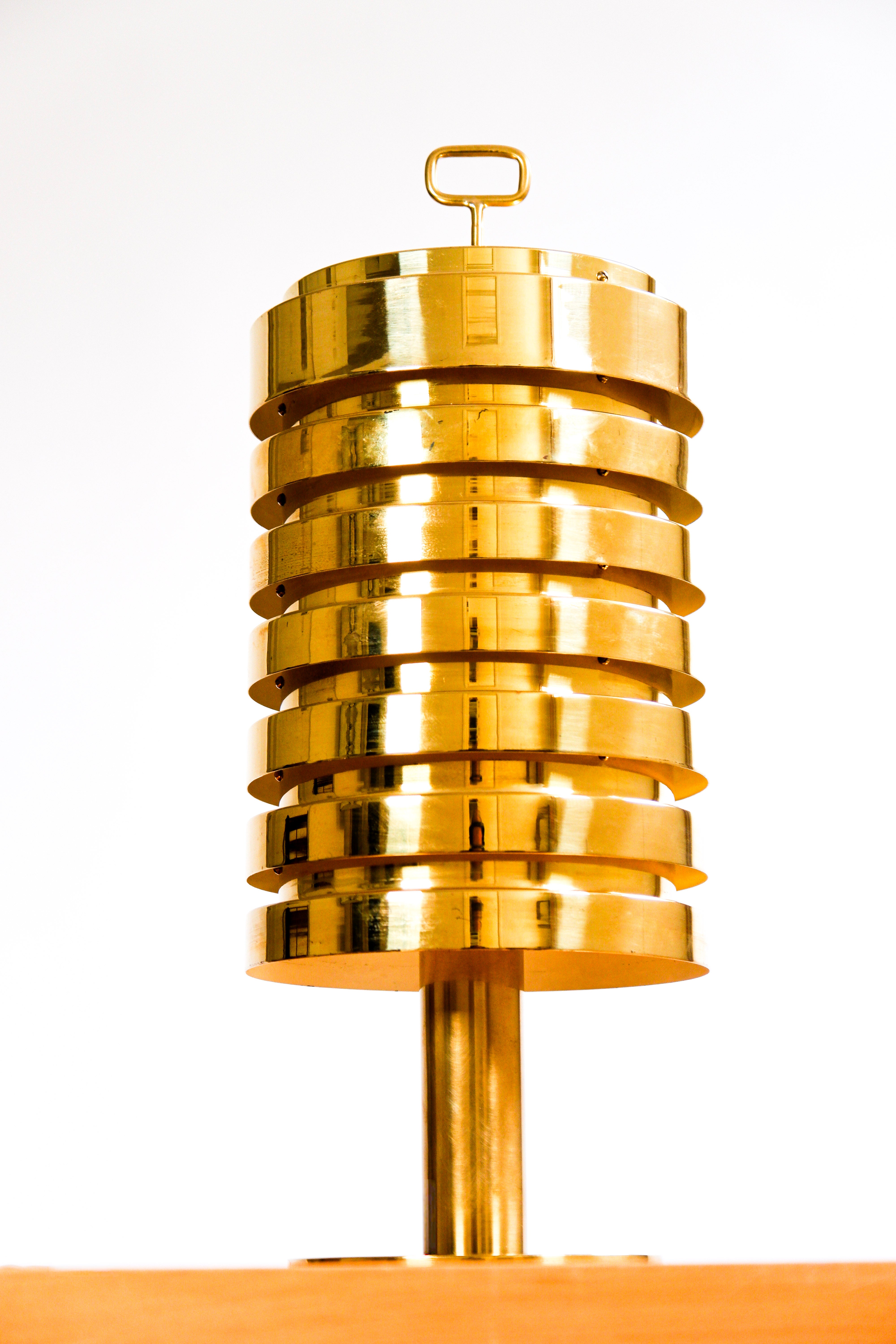 Questa lampada da tavolo B99 è un sorprendente design moderno di metà secolo, altamente scultoreo e dal carattere inconfondibilmente scandinavo.
La lampada è realizzata in ottone lucido con una calda lucentezza dorata. Il paralume è composto da più