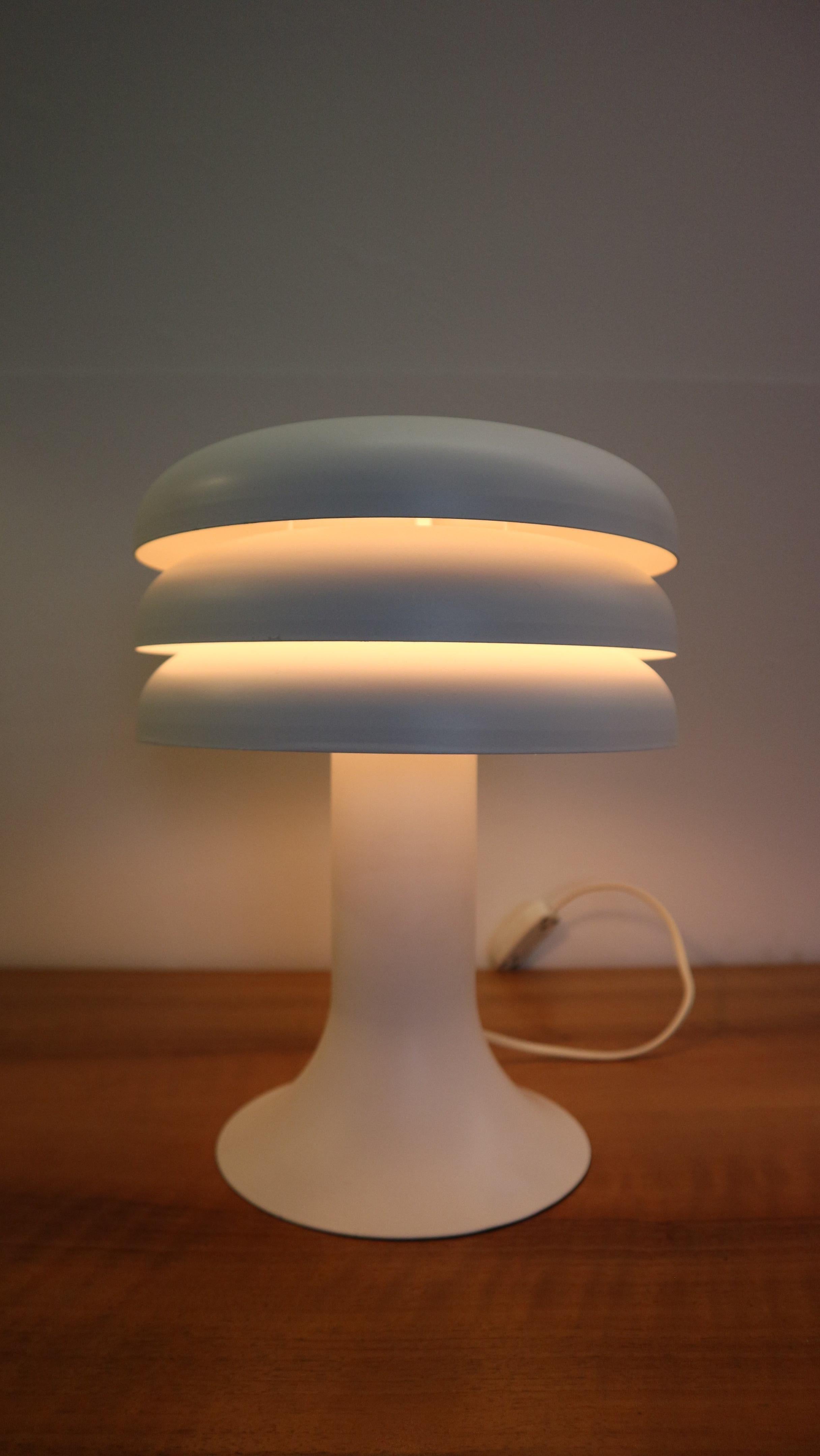An iconic piece of Mid-century design lighting. This table lamp, model BN-25, is a recognizable design by popular Swedish designer Hans Agne Jakobsson. It is made of high quality white lacquered aluminium. The top is made of three round parts with a