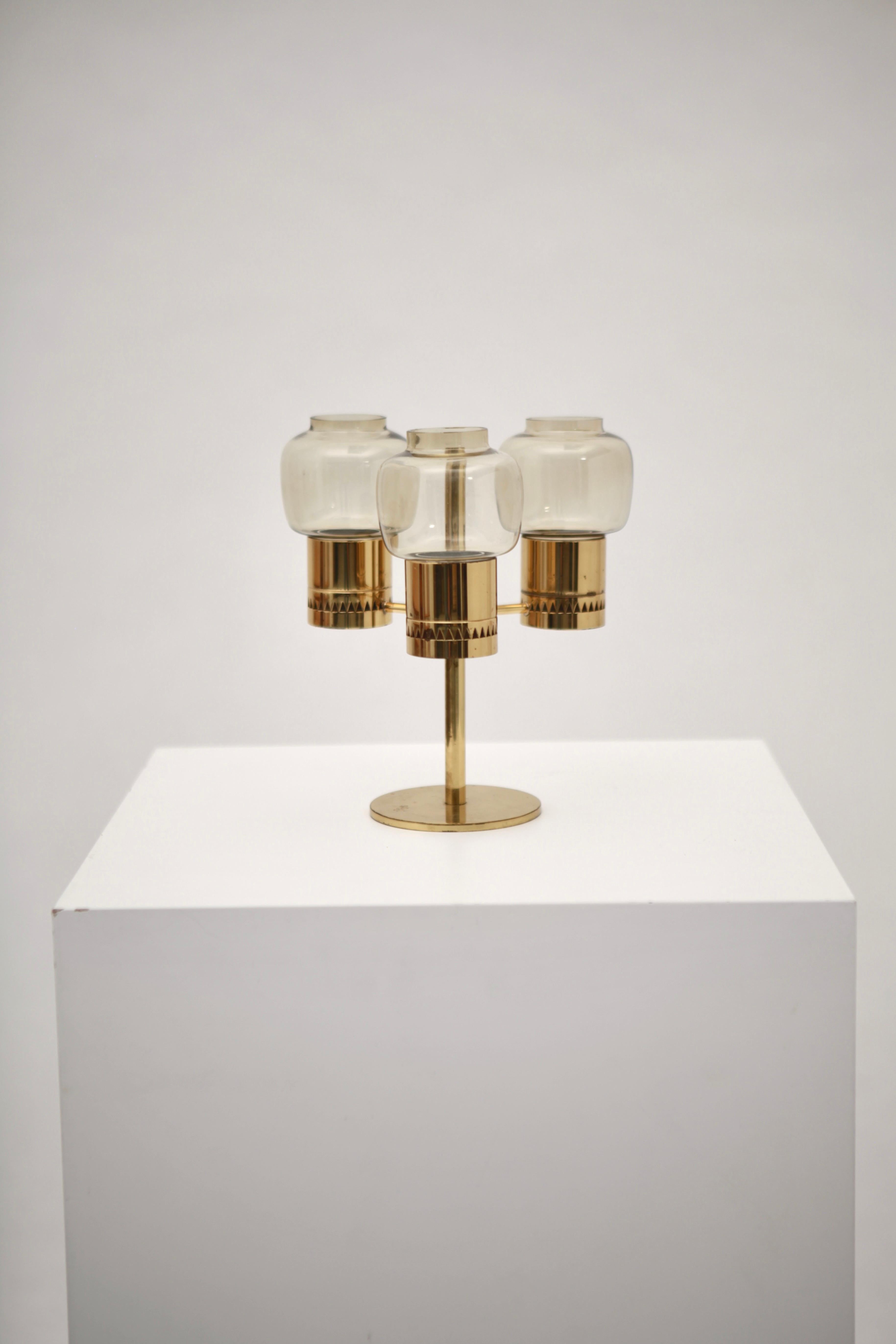 A rare three-armed candelabra designed by Hans-Agne Jakobsson, Markaryd Sweden, 1950s.
Polished brass and hand blown clear glass shades, model 'L 67'.
 