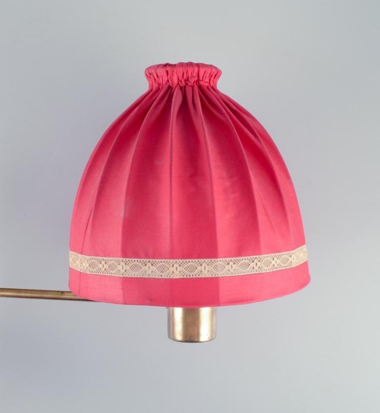 Hans-Agne Jakobsson. Wandleuchte aus Messing mit einem Lampenschirm aus rotem Stoff (Mitte des 20. Jahrhunderts) im Angebot