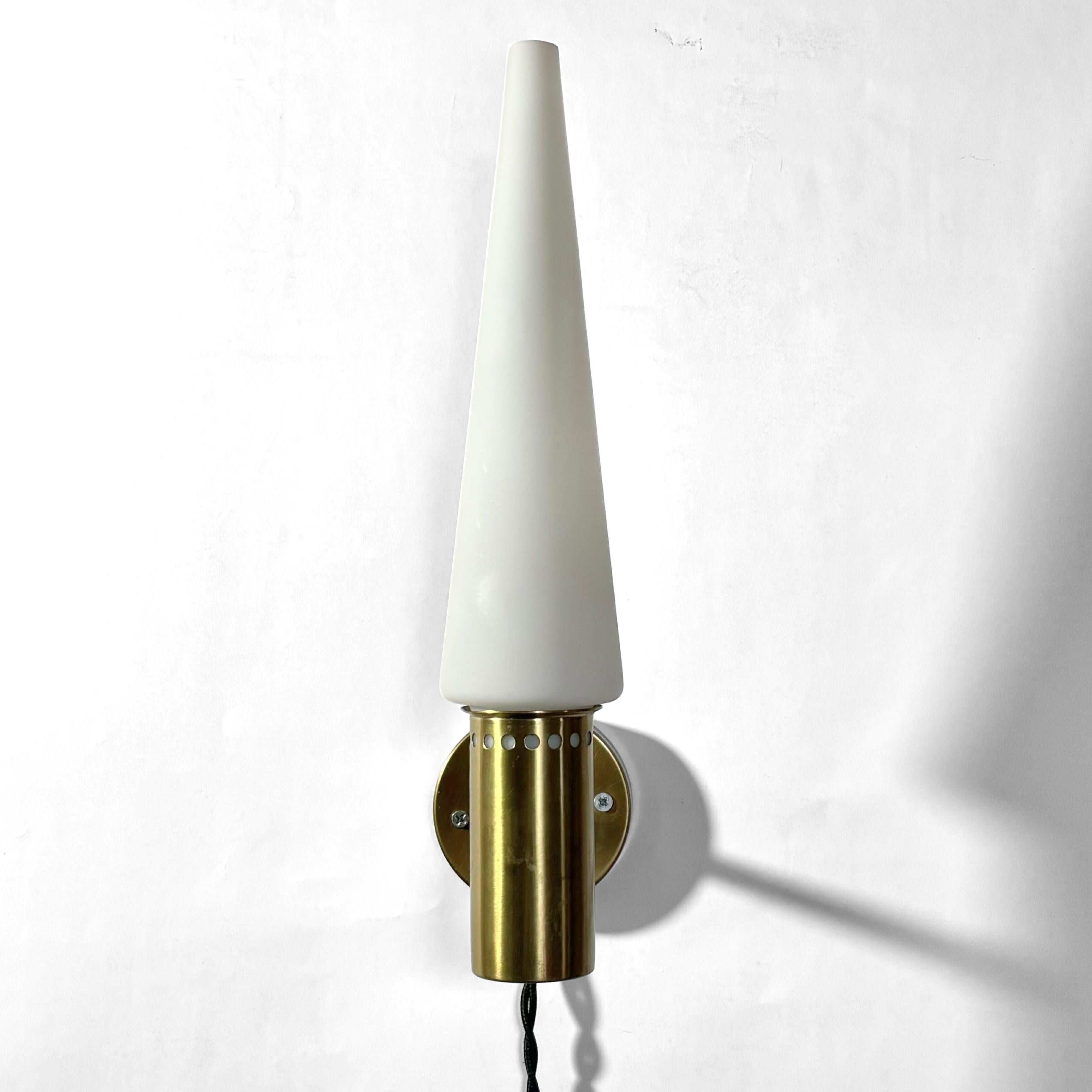 Eine minimalistische Wandleuchte, Modell S-1986, entworfen von Hans-Agne Jakobsson in den 1960er Jahren für seine Firma Hans-Agne Jakobsson AB in Markaryd. Sie ist aus Messing gefertigt und verfügt über einen kegelförmigen Glasschirm, der von einem