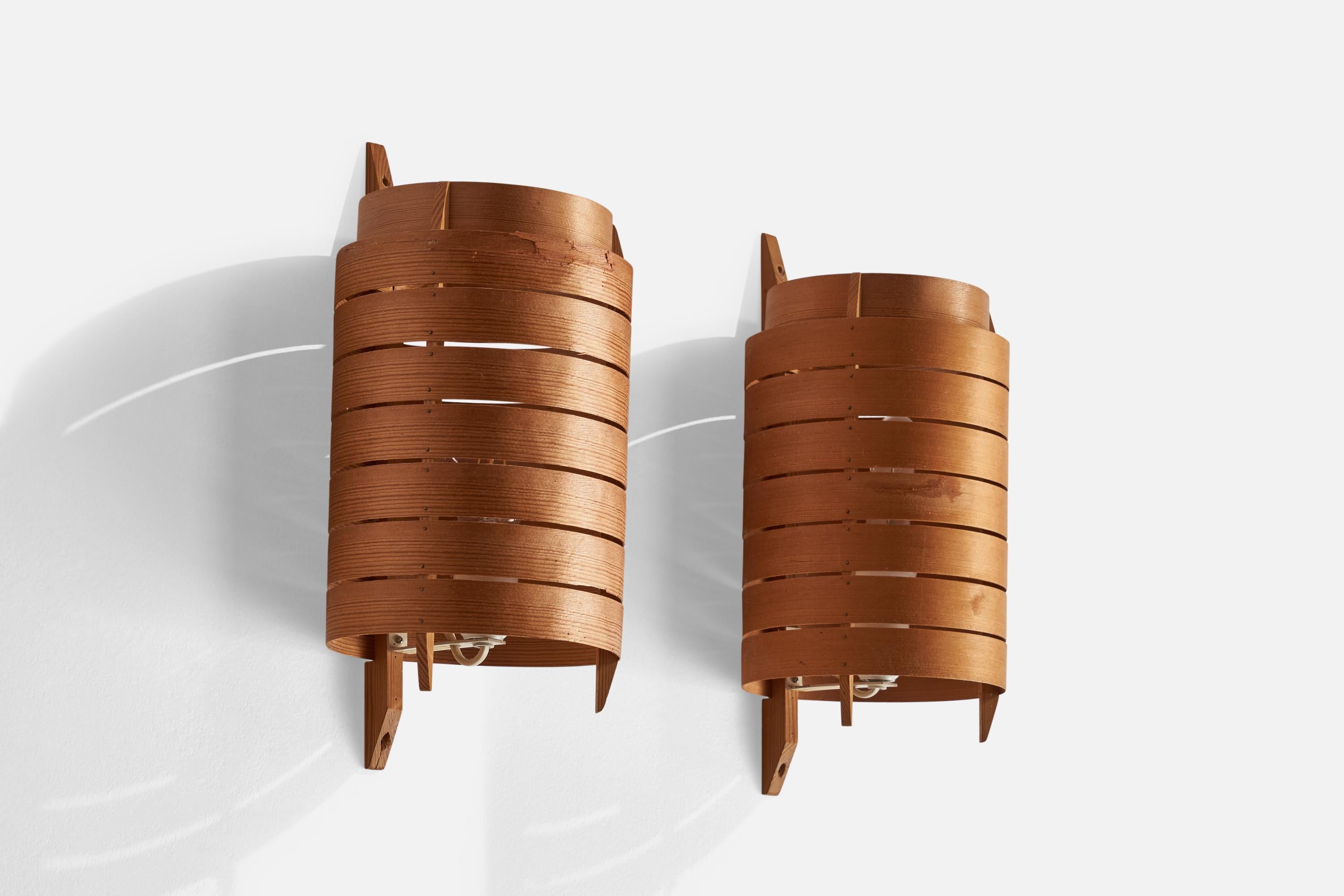 A pair of pine and moulded pine veneer wall lights designed and produced in Sweden, 1960s.

Overall Dimensions (inches): 14.5” H x 6.75”  W x 7” D
Back Plate Dimensions (inches): n/a
Bulb Specifications: E-26 Bulb
Number of Sockets: 2
All lighting
